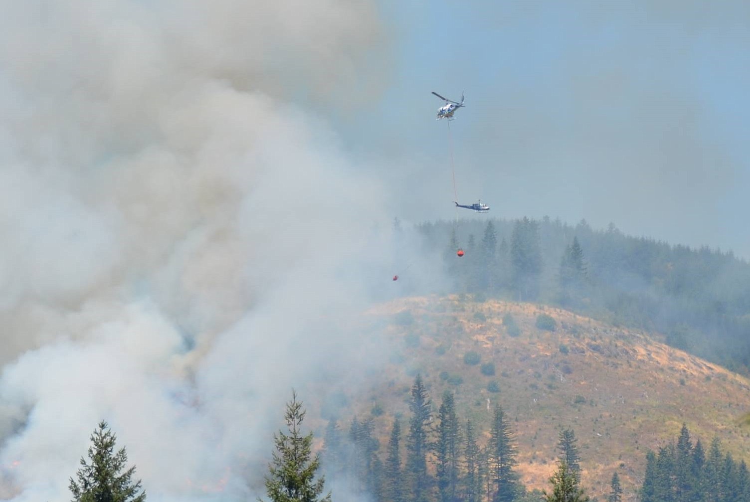 Crews battle a wildfire from the air Sunday as it burned northeast of Woodland near state Highway 503 and Fredrickson Road.