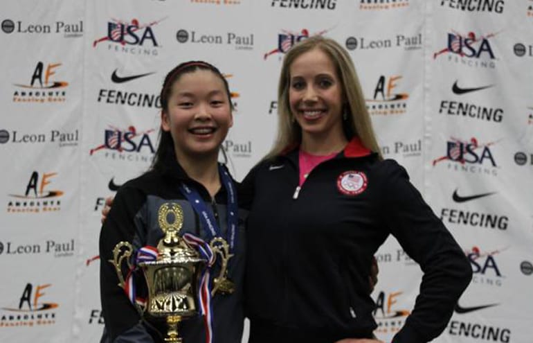 Malia Hee of Vancouver, left, received her gold medal from Olympic champion Mariel Zagunis after Friday's cadet women's sabre championship at the USA Fencing Junior Olympics.