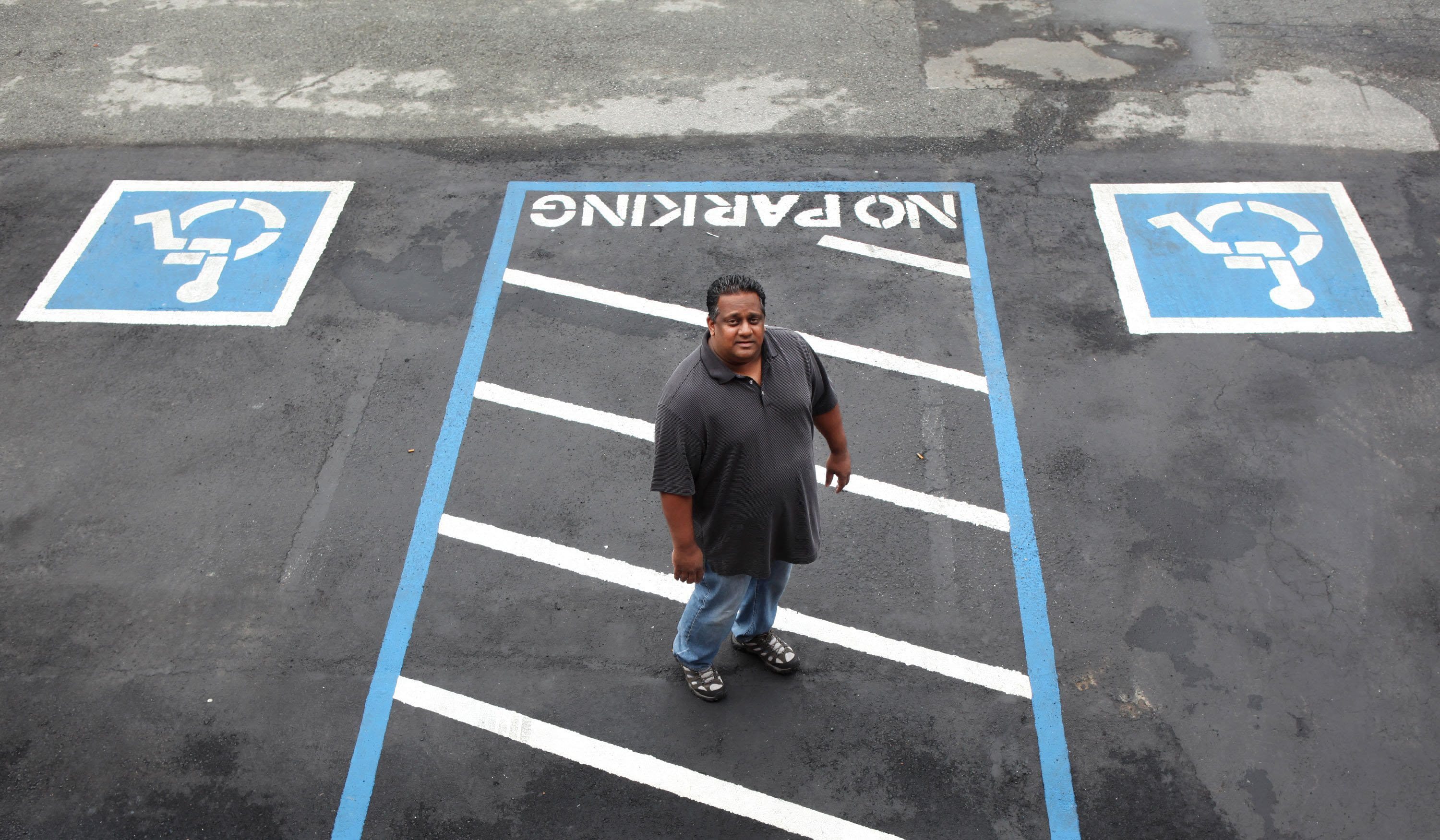 Vikas Patel, owner of the EconoLodge in Santa Clara, Calif., shows the handicapped parking he added after being sued for alleged ADA violations.