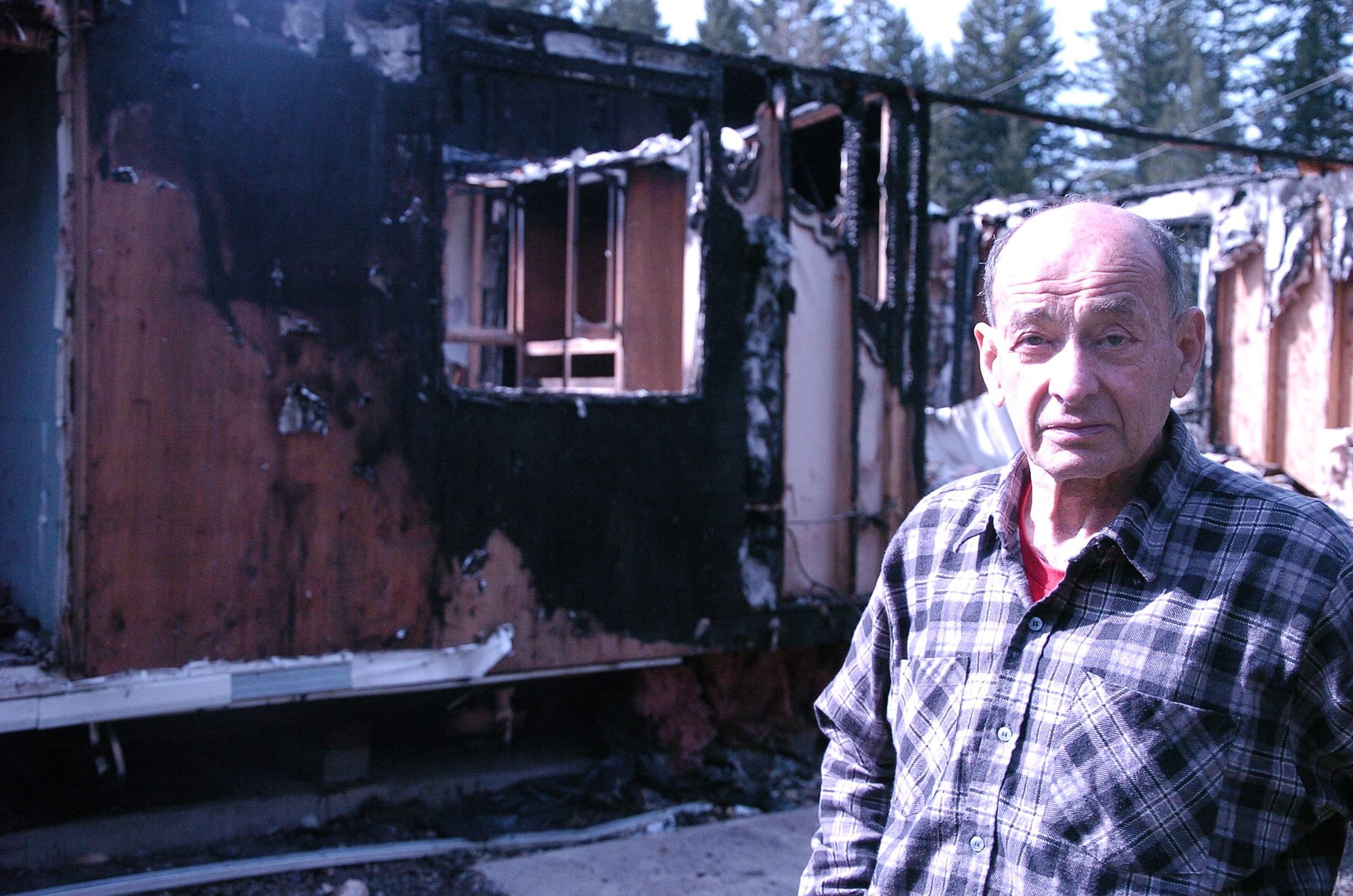 Ed Rodda stands before the charred remains of his double-wide mobile home in La Center.
