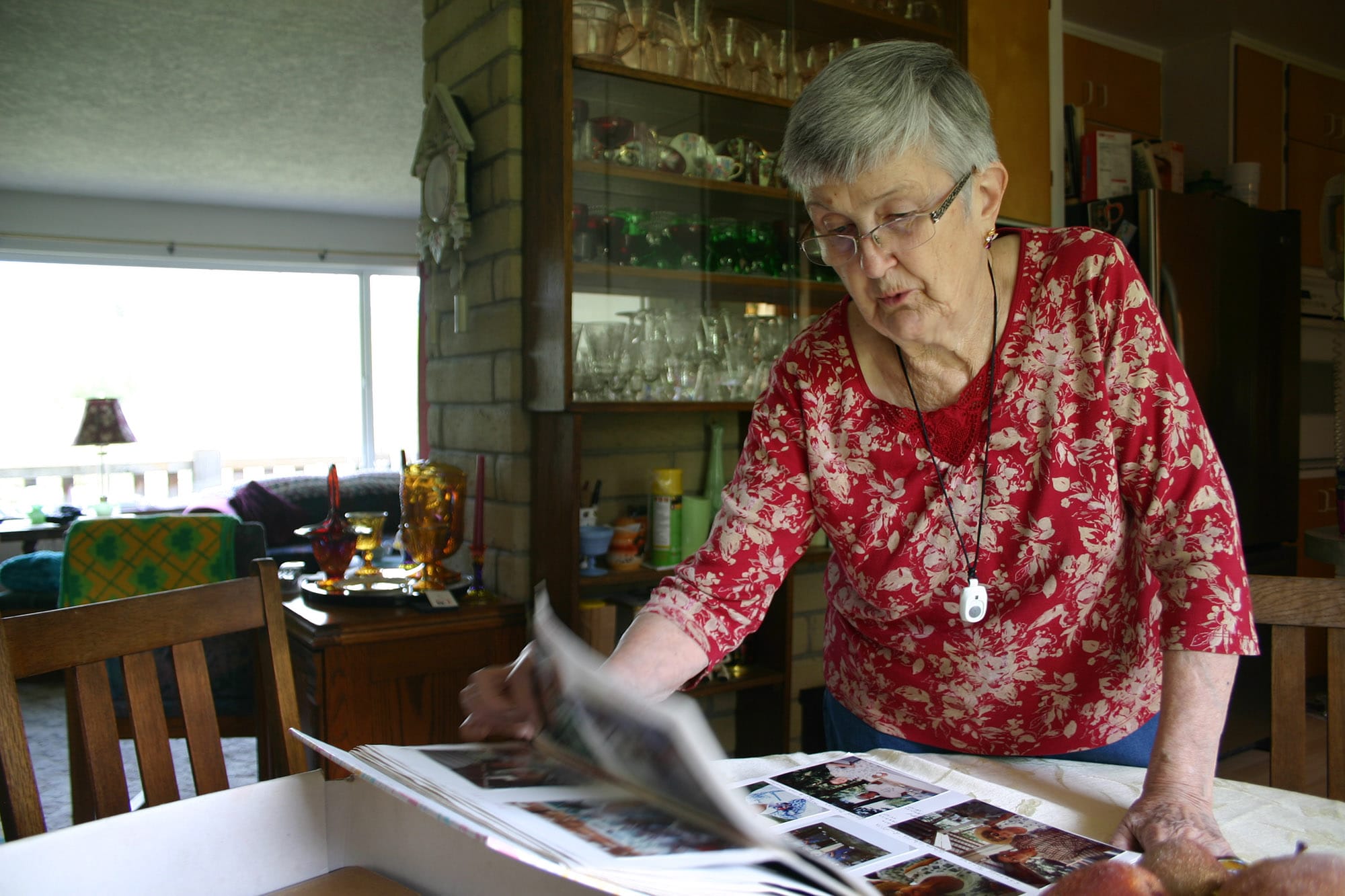 Wanda Turner flips through photos of friends, classmates and teachers at her potlucks over the years.