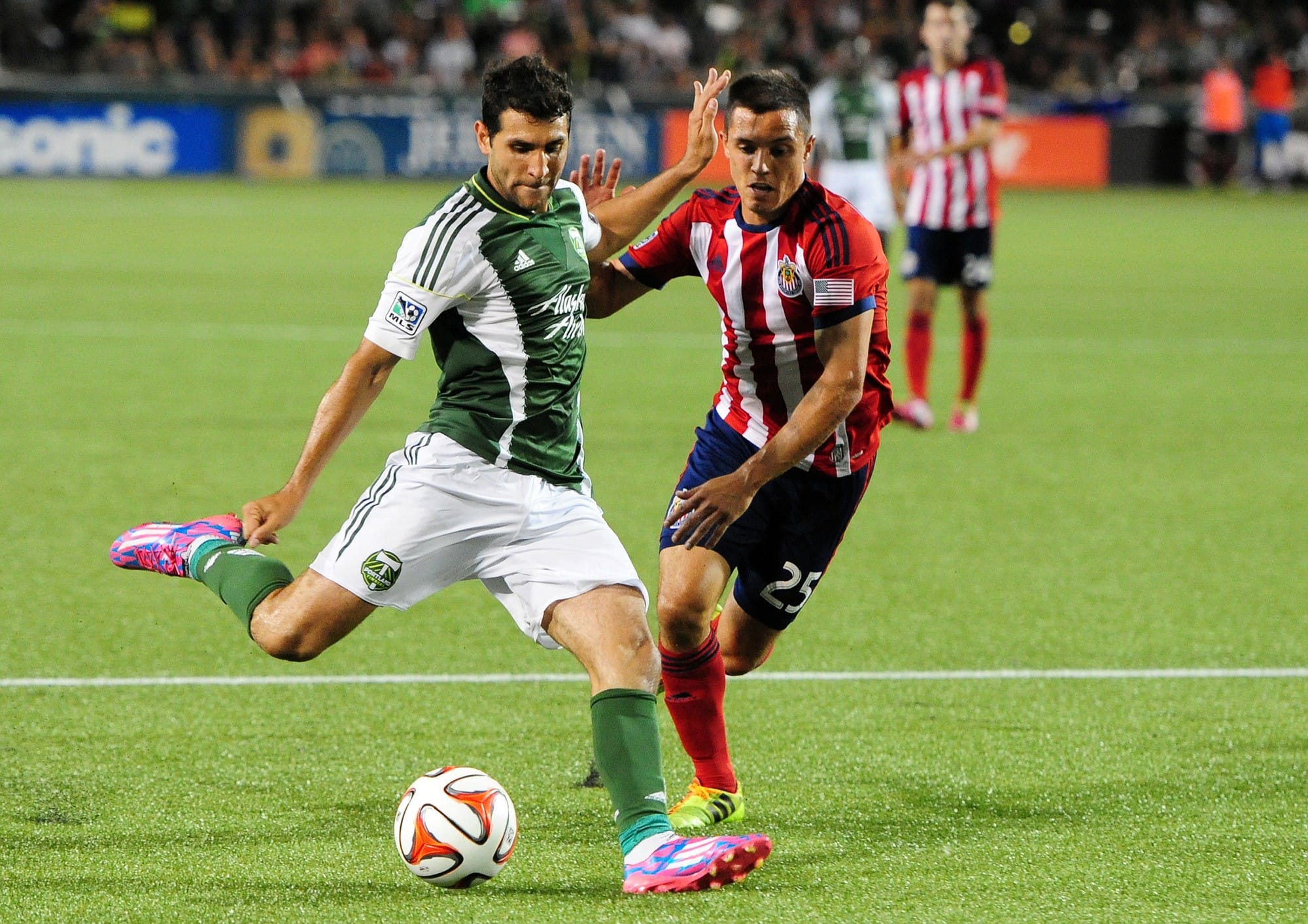 Portland Timbers midfielder Diego Valeri, left,puts a shot on goal as Chivas USA defender Donny Toia closes in during the second half of an MLS soccer game in Portland, Ore., Saturday, Aug. 9, 2014.