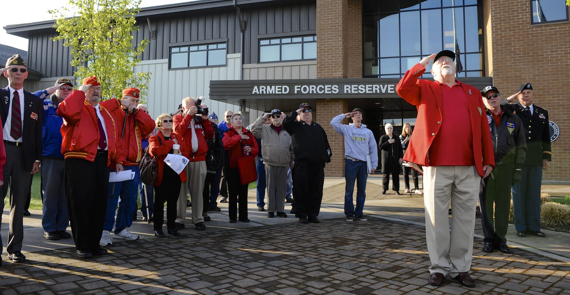 Jerry Keen, at right, leads a salute to the flag as members and supporters of the nonprofit Community Military Appreciation committee gather to dedicate a stone at a POW/MIA memorial at the Armed Forces Reserve Center.