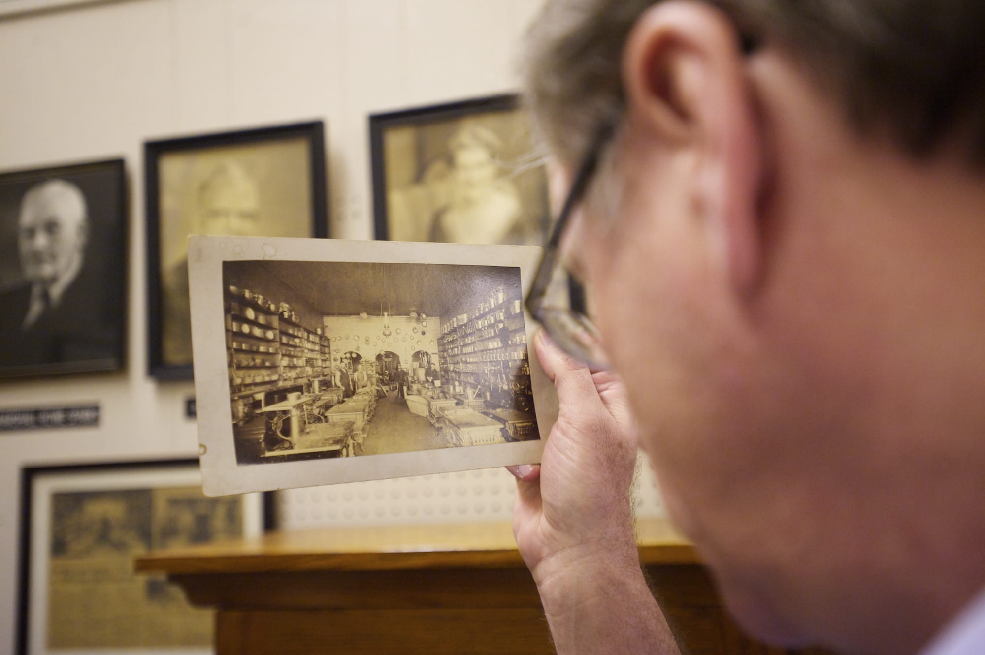 Tom Craig examines a vintage photograph that shows an earlier version of the Sparks store in downtown Vancouver.