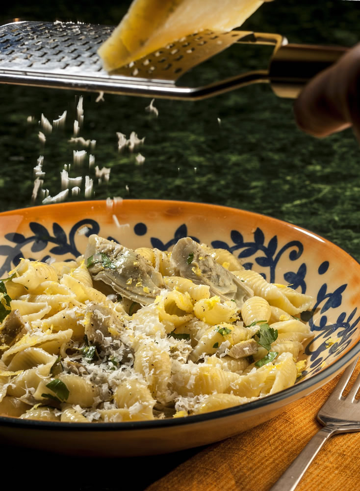 Lemon zest brightens the flavor while a little cream adds richness to this dish of pasta shells with artichokes.