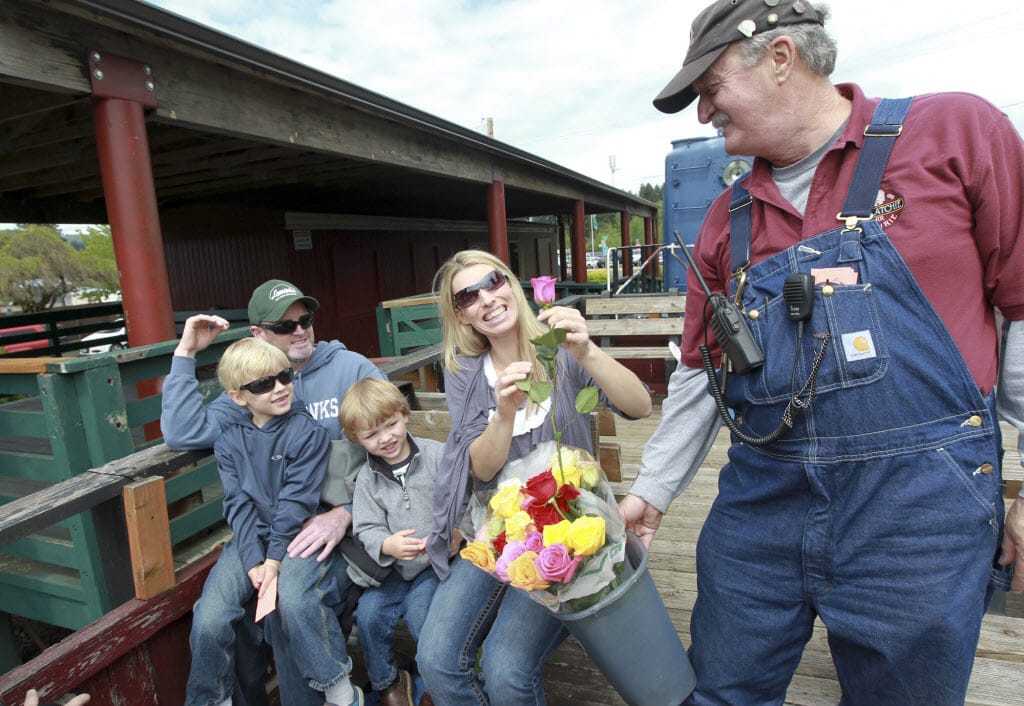 Randy Williams, president of the Chelatchie Prairie Railroad organization, hands out Mother's Day roses Sunday in Yacolt.
