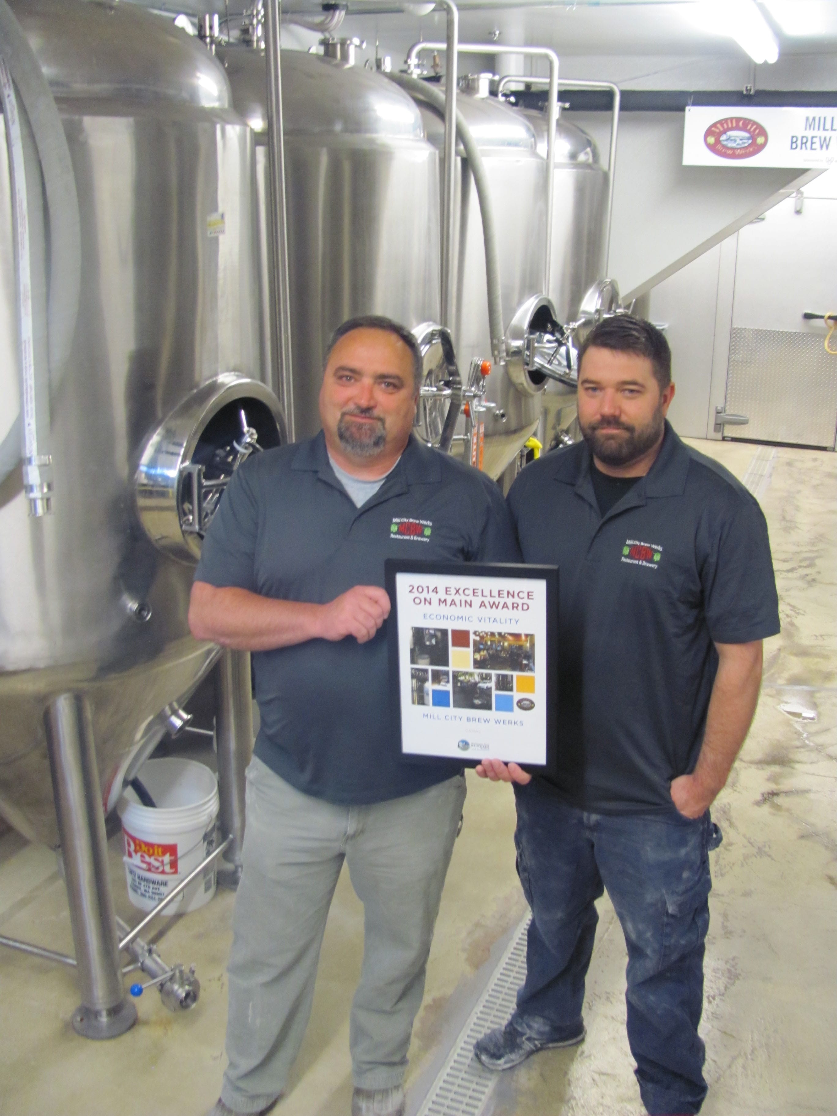 Mill City Brew Werks owner Mark Zech (left) and General Manager/Brewer Chris Daniels (right) stand with an Excellence on Main award from the Washington State Main Street Program.
