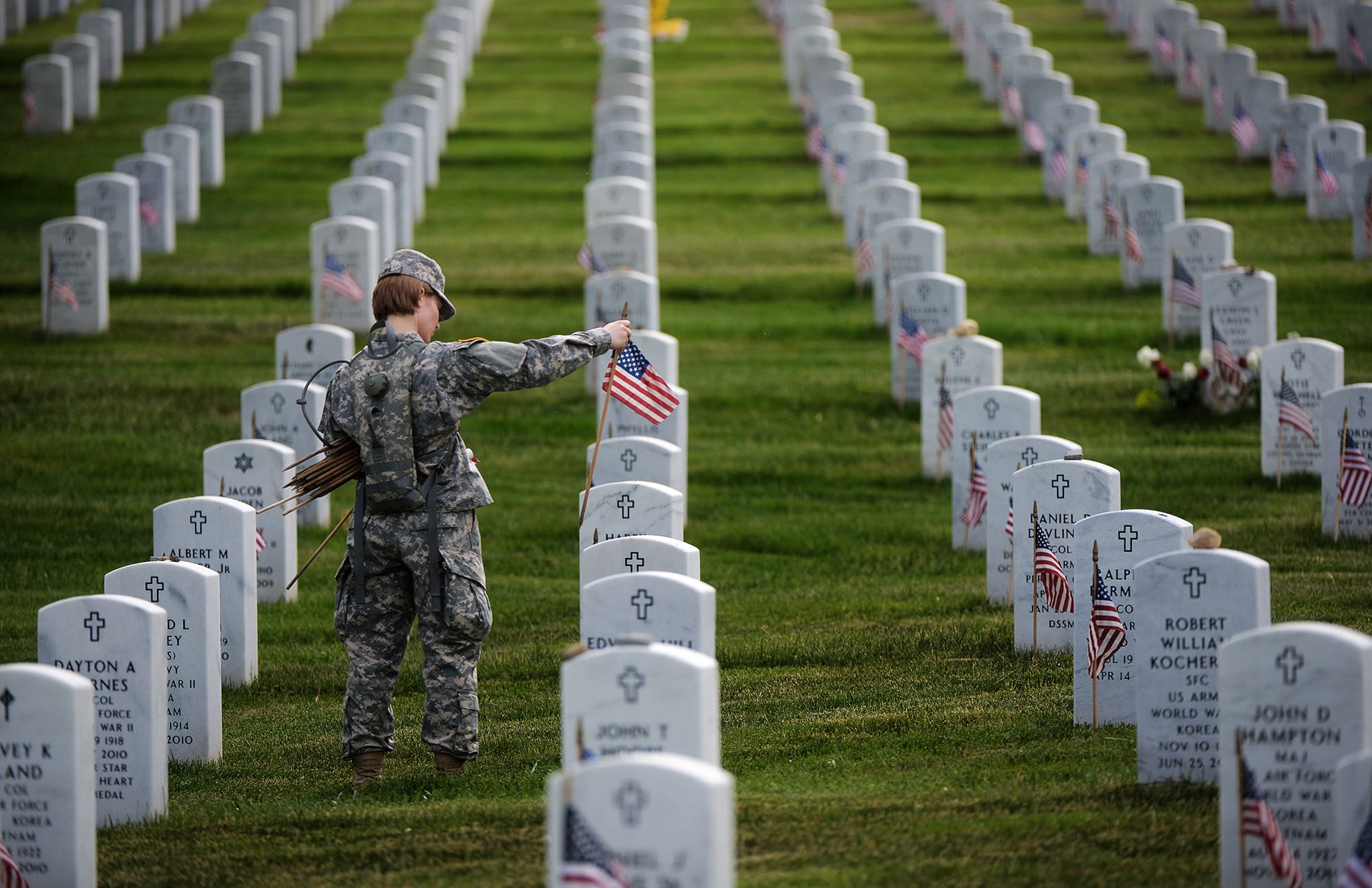 Bill O'Leary/The Washington Post
Staff Sgt. Kerrin Kampa, of the Old Guard Fife and Drum corps, places flags in front of headstones at Arlington Memorial Cemetery for Memorial Day in 2013 in Arlington, Va. The cemetery has been added to the National Register of Historic Places.