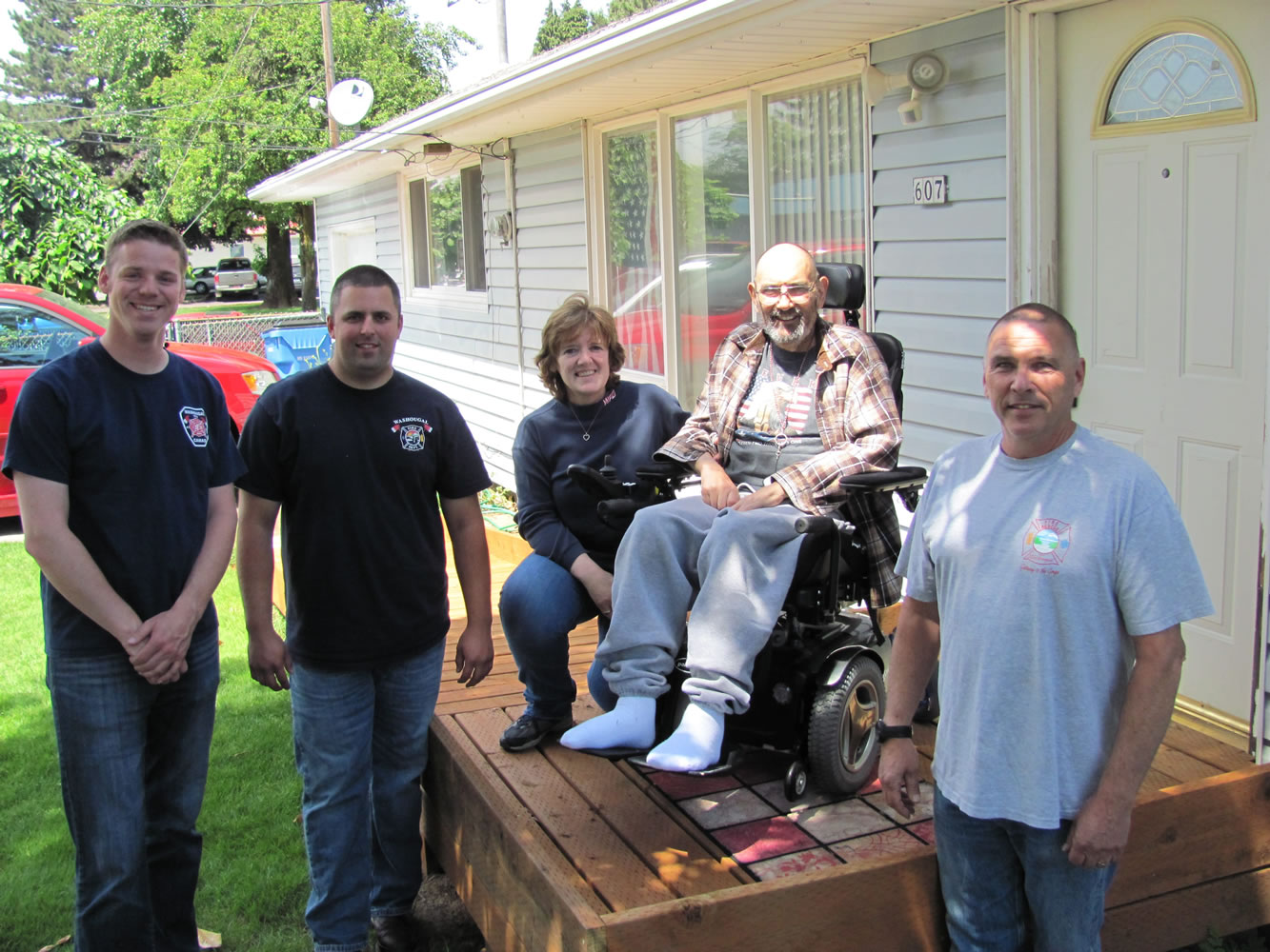 Several local fire officials recently coordinated the donation and installation of a ramp for Bob Dawson (second from right), who was diagnosed with ALS in 2013. Recently appearing with him were Jordan Boldt, Jake Grindy, Dawson's wife Charlie, and Joe Scheer. Charlie has served as a Washougal volunteer firefighter for more than 23 years. &quot;They shocked us,&quot; Charlie said, regarding the addition of a ramp.