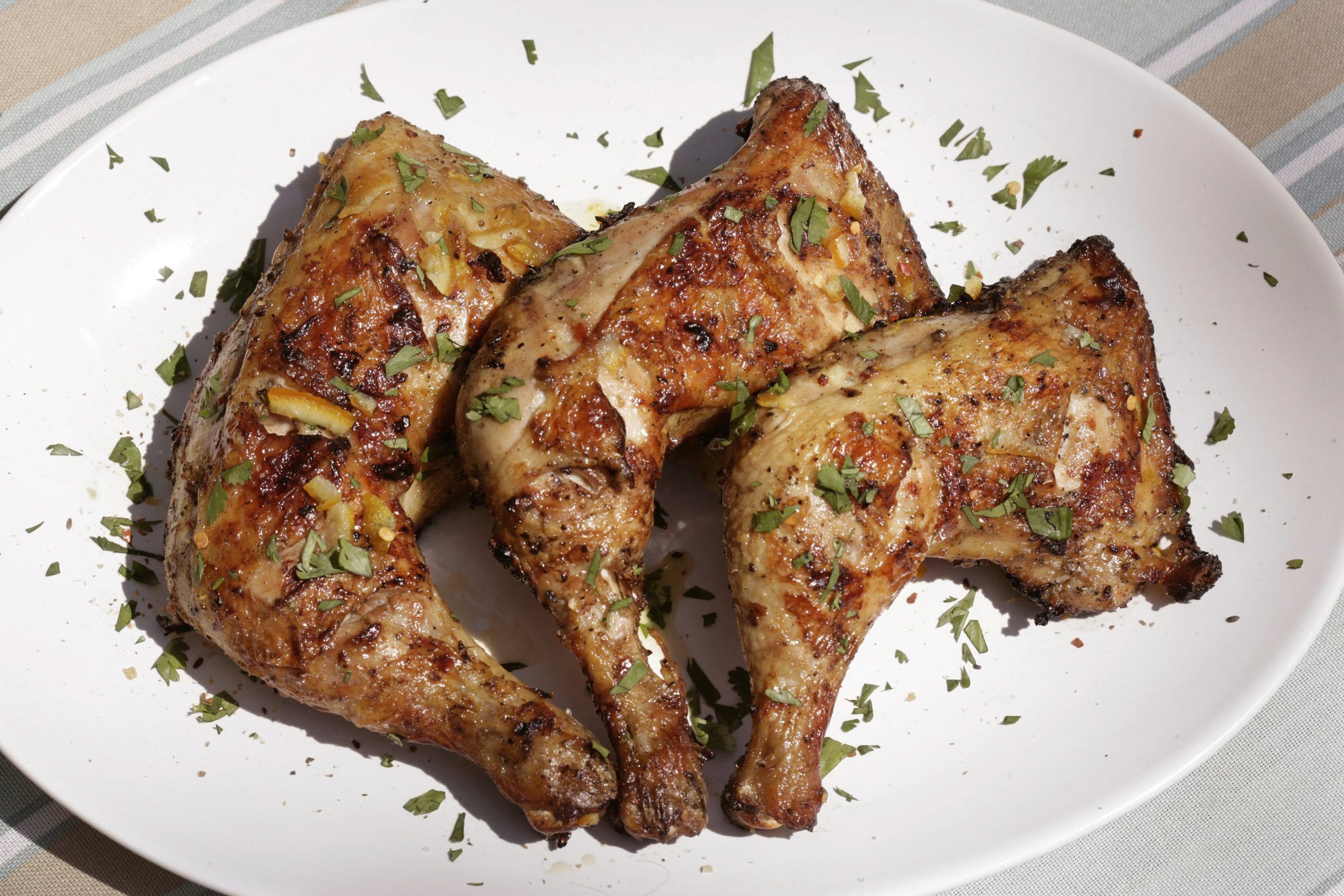 Using two heat zones on the grill is key to preparing bone-in chicken legs such as these spicy garlic chicken leg quarters.