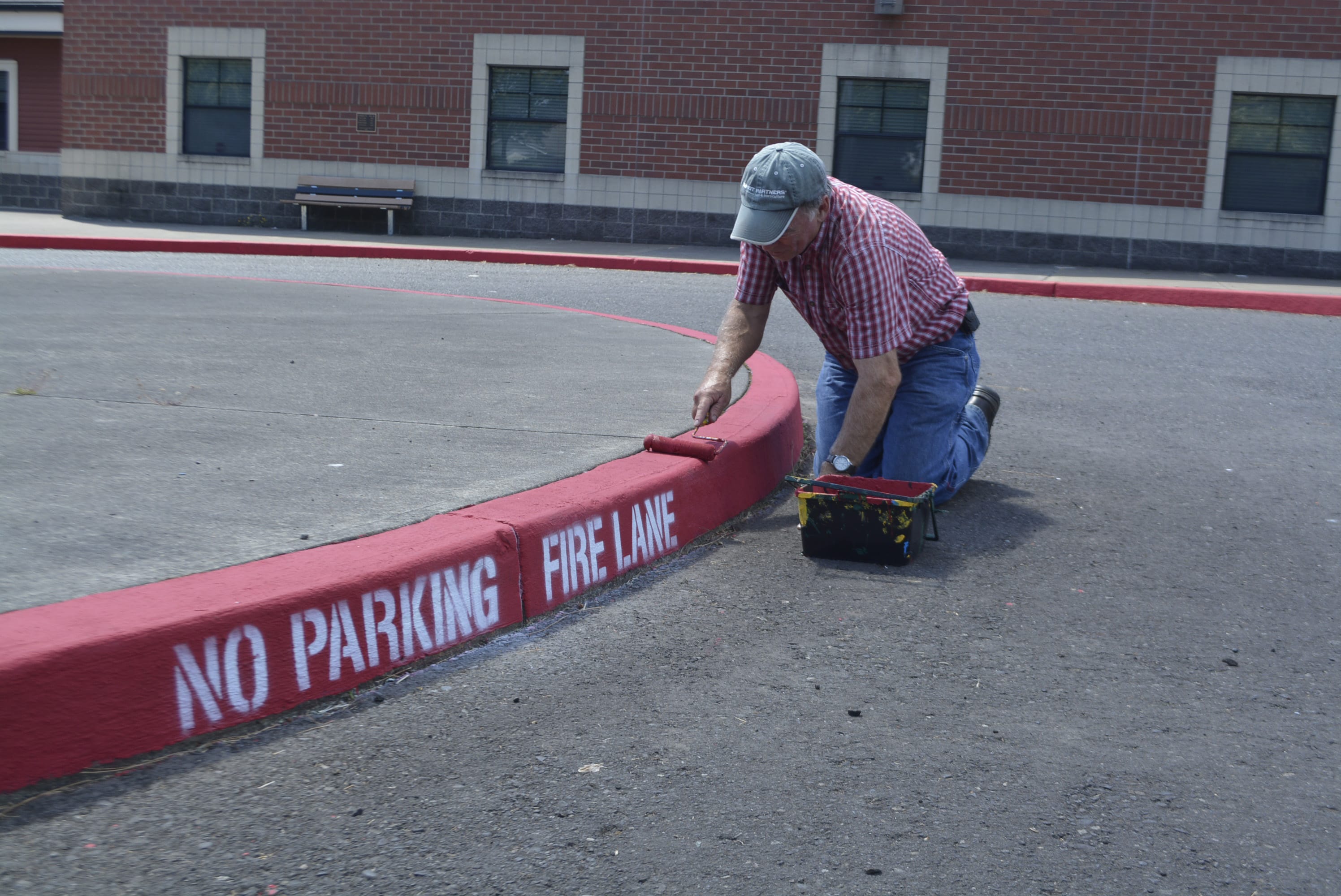 Jack Walker from the WSD Maintenance Department repaints the fire lane area at the Washougal High School parking lot.
