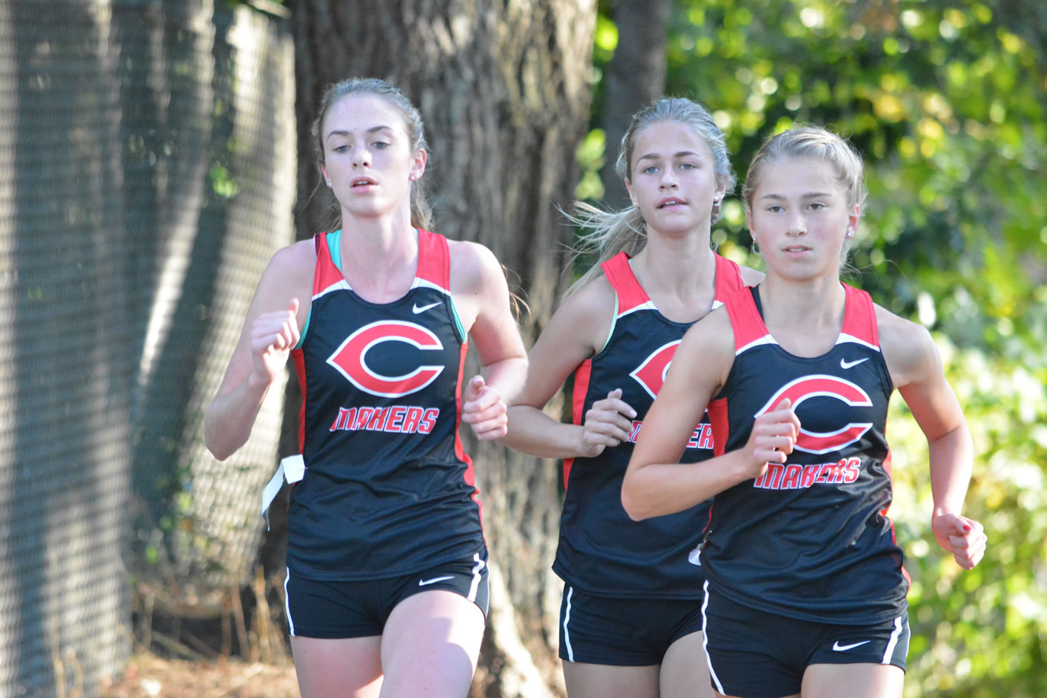 Camas cross country runners, from left, Emma Jenkins, Emily Wilson and Rachel Blair compete during a meet this season at Round Lake Park in Camas.