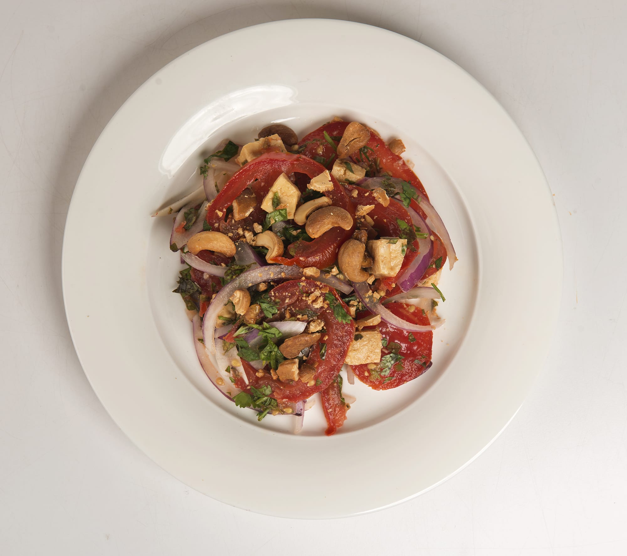 Tomato and Tofu Salad balances sweet, tart, spicy and earthy; tofu  bridges the softness of the tomatoes and the crunch of the nuts and onions.