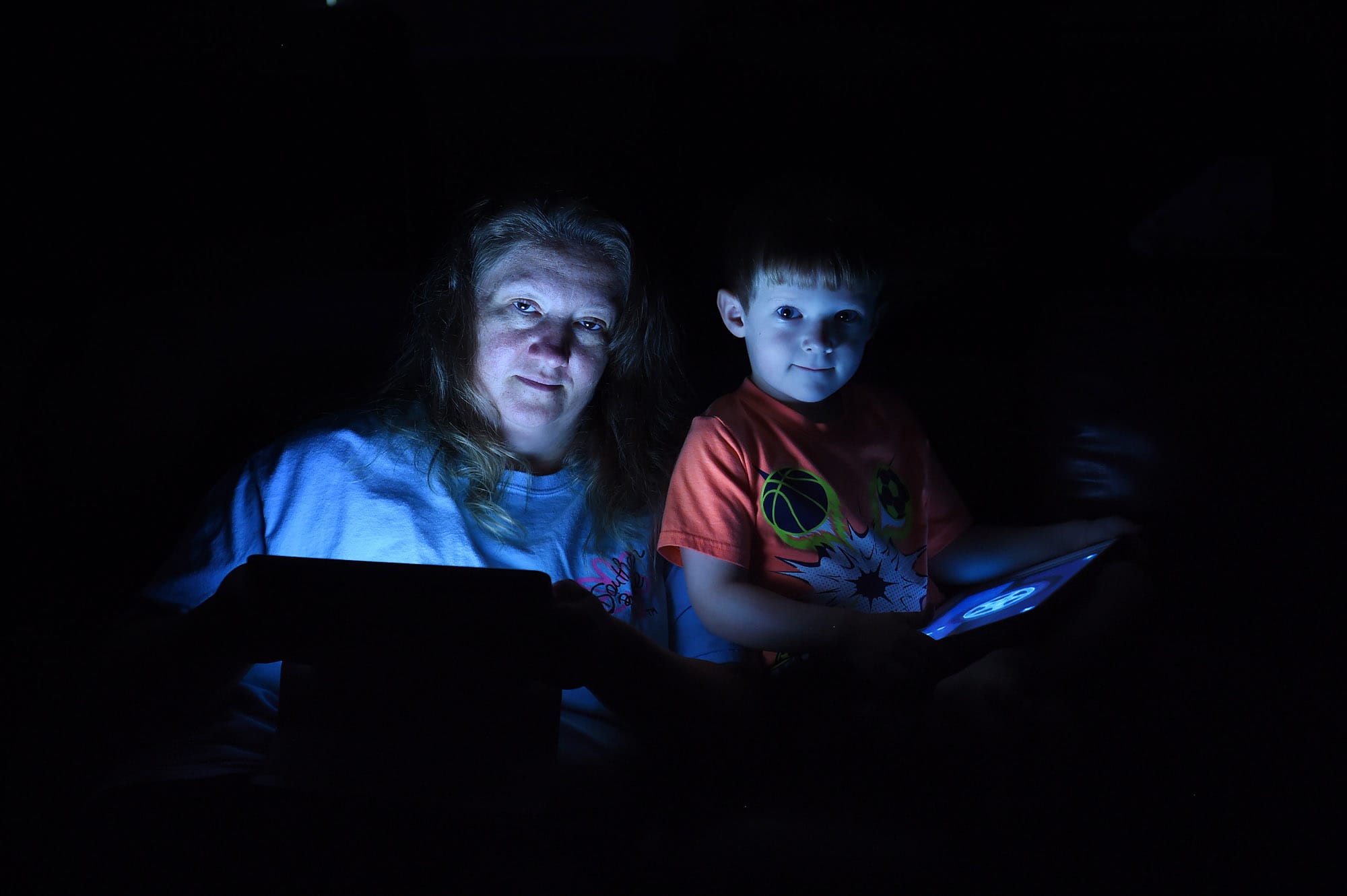Cassie Lauterette and her son, Ashton, 4, are illuminated by the glow of the tablets that control many of their home&iacute;s functions. Illustrates SMARTHOMES (category l), by Audrey Hoffer, special to The Washington Post. Moved Monday, August 31, 2015.