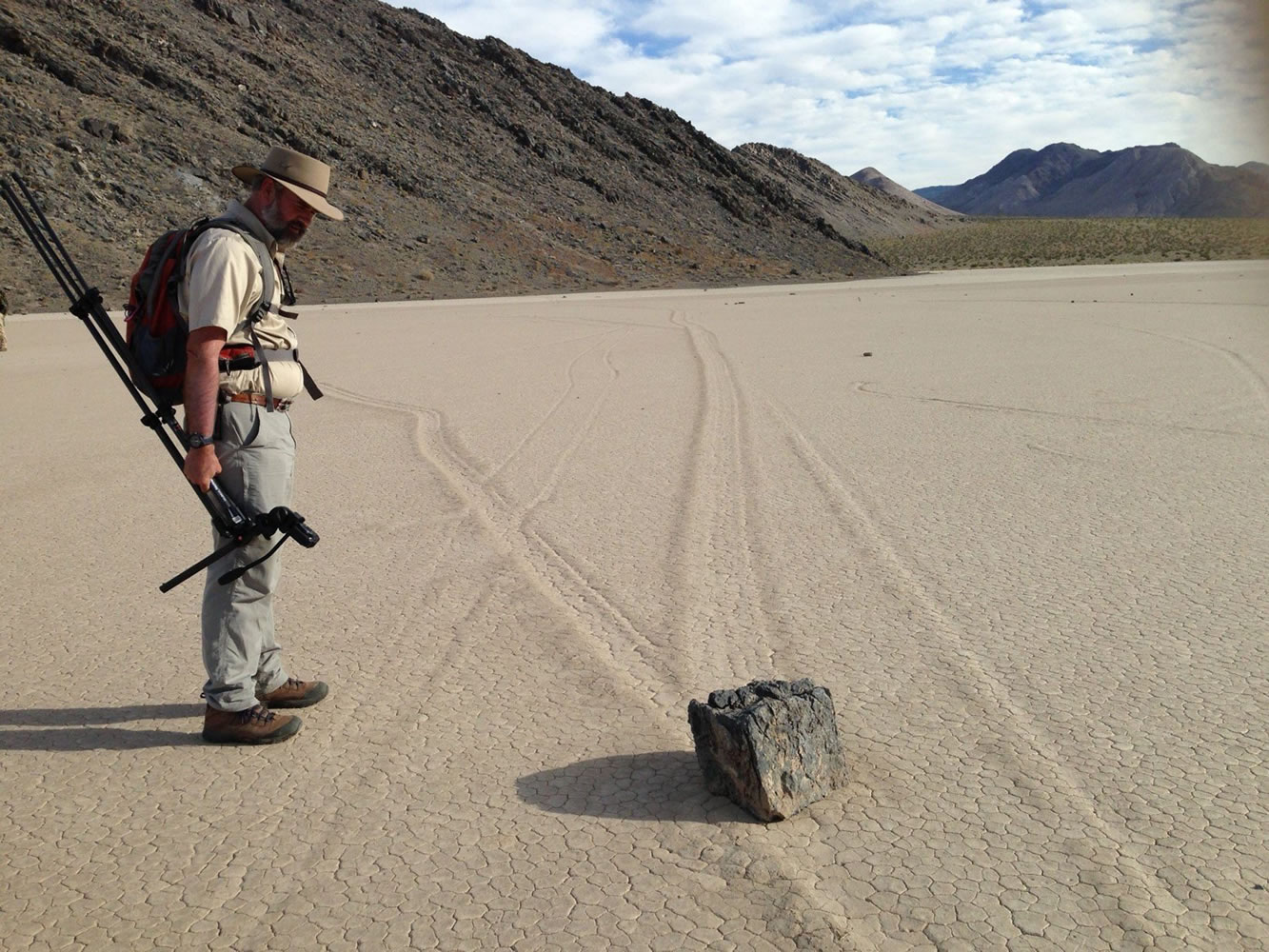 Richard Norris surveys one of several hundred rocks that have left trails as they moved across the surface of Racetrack Playa in California's Death Valley National Park on Aug. 18.