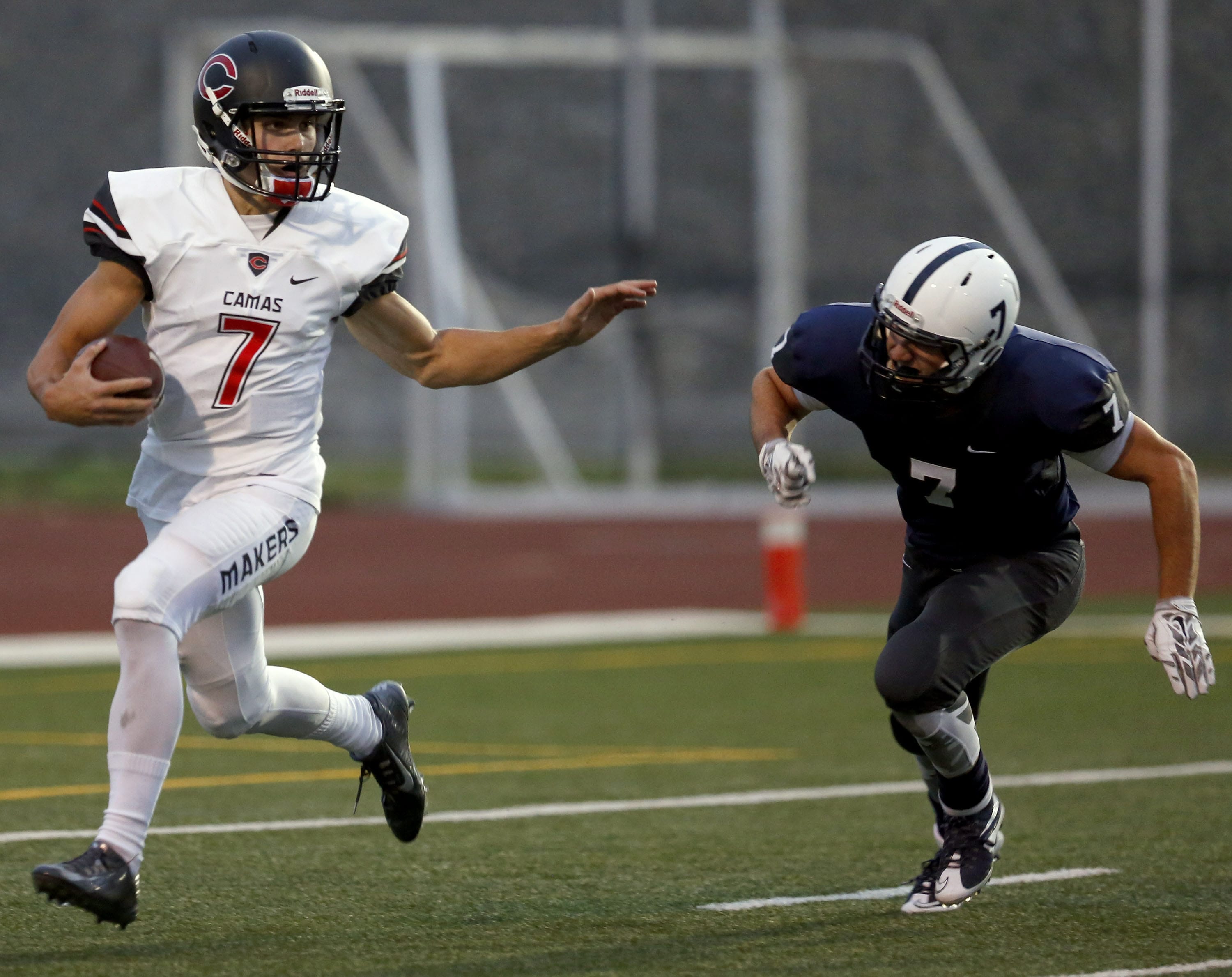 Camas High School's Liam Fitzgerald, left, moves past a tackle attempt from Chiawana High School's Josh Wilson during a Sept.