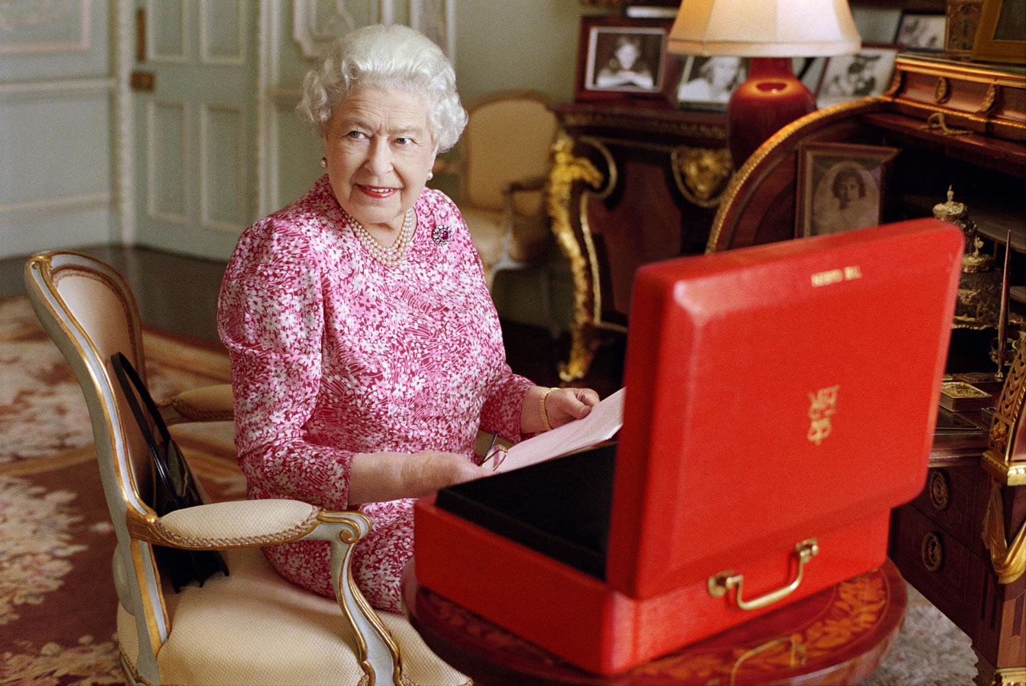 Britain's Queen Elizabeth II sits at her desk in her private audience room at Buckingham Palace in London with one of her official red boxes that she has received almost every day of her reign. It contains important papers from government ministers in the United Kingdom and her Realms and from her representatives across the Commonwealth and beyond.