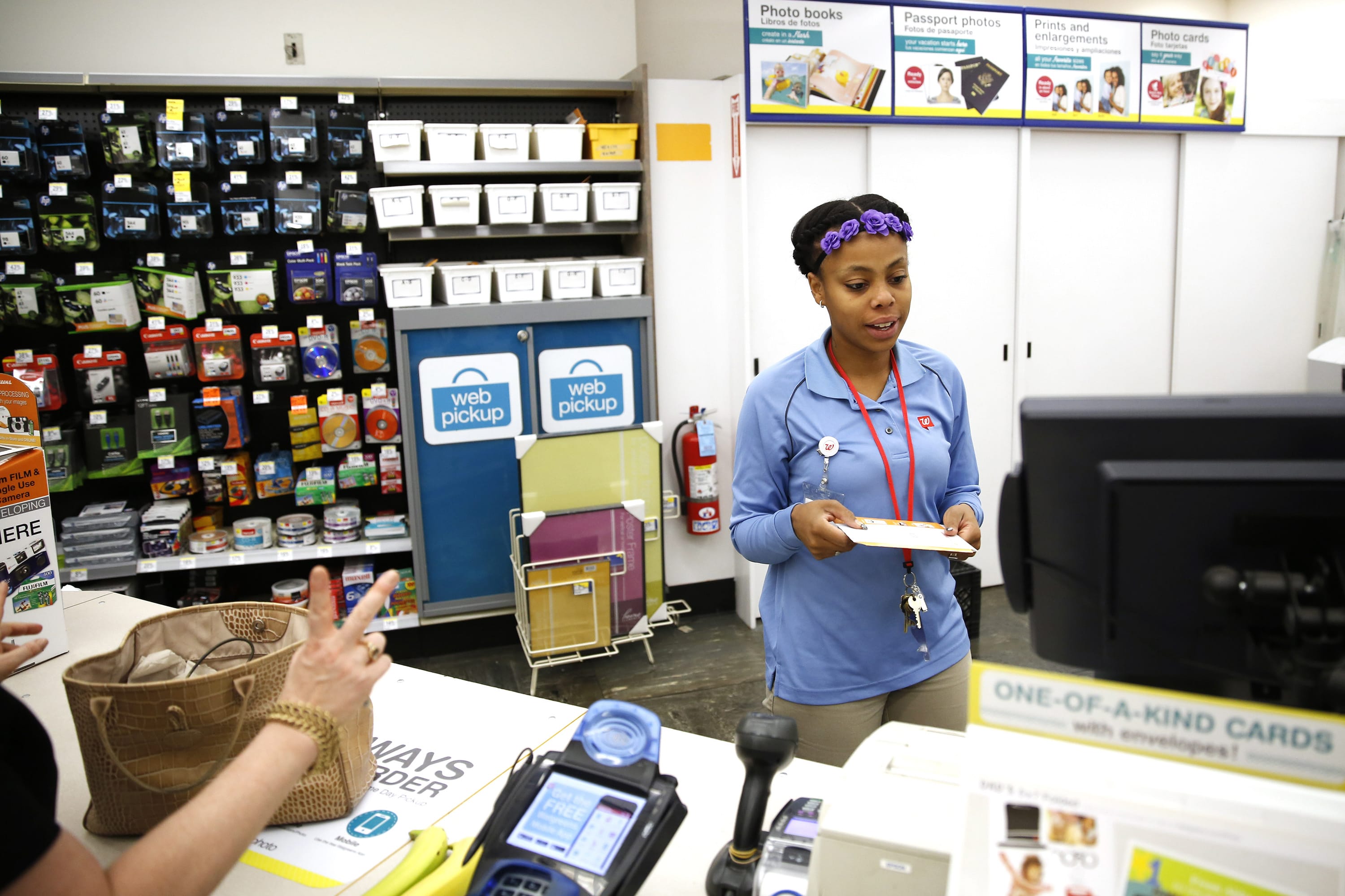 Walgreens photo specialist Lashaunda Williams helps check out customer Linda Dalyas she picks up prints from her Alaska and Vancouver, B.C., vacation at the store&#039;s photo lab on Thursday in Chicago. (Jose M.