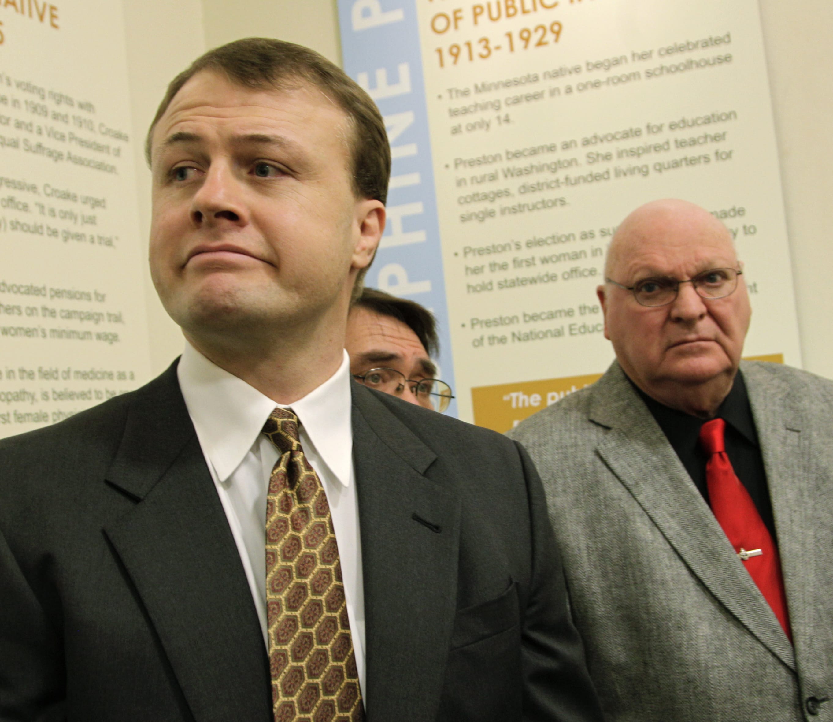 Activist Tim Eyman, left, listens to a question from a reporter, accompanied by Mike Fagan, center, and Jack Fagan after Eyman filed an initiative Jan. 11 to require the state Legislature to muster a two-thirds vote to raise taxes. (Ted S.