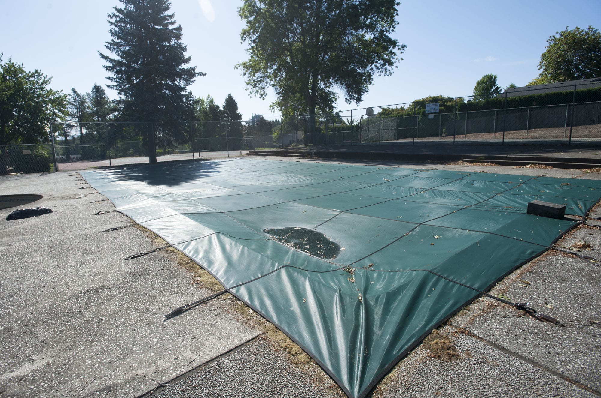 The Mount Vista neighborhood pool is seen covered and fallen in to disrepair in Ridgefield Thursday July 23, 2015.  The board  of the  Mount Vista Homeowners Association voted to decommission the pool, after the health department said it has pathogens, but some neighbors disagree.
