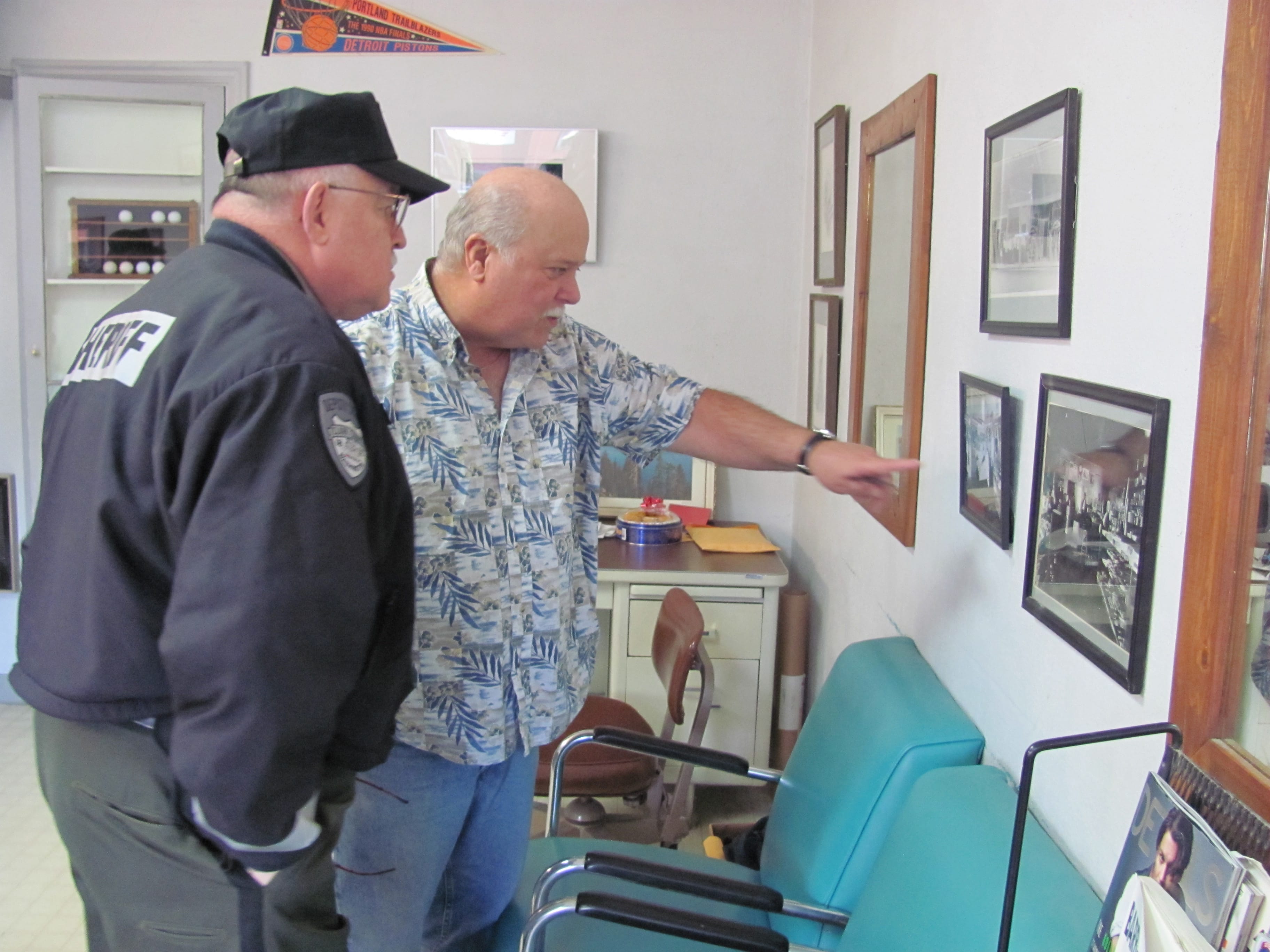 Retiring Clark County Sheriff Garry Lucas (left) recently looked at historical photos of downtown Camas, with Lyle Shaver (right), former owner of Sportsman Barber Shop. That business is located at 214 N.E.