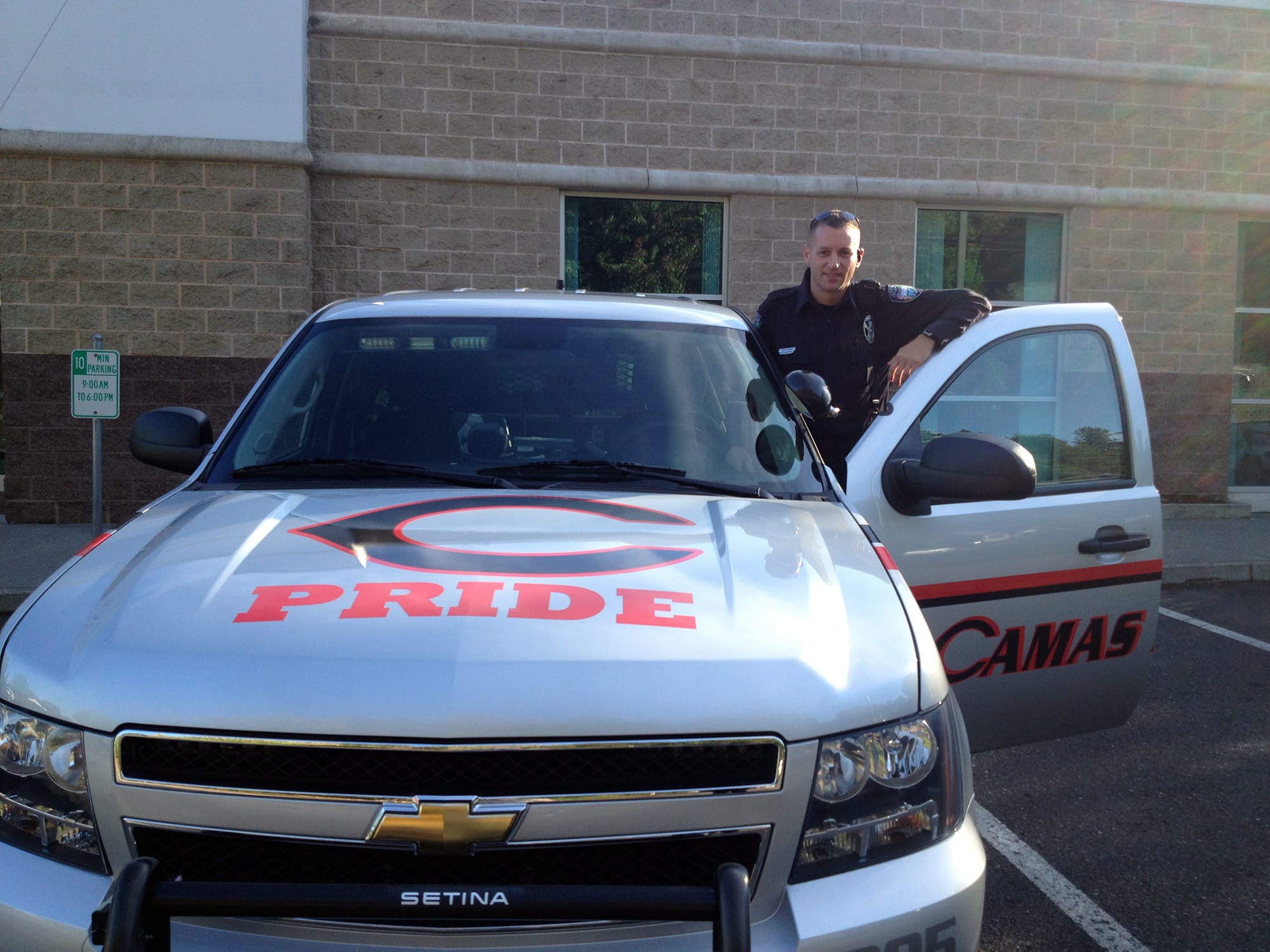 Camas Police Officer Tim Fellows, the Camas School District's school resource officer, with his newly restriped, Camas Papermakers-themed patrol car.