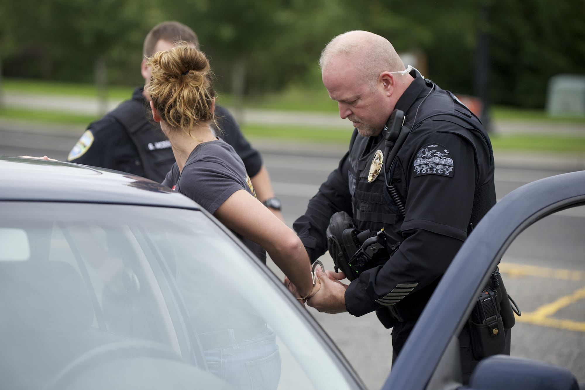 Ridgefield police Officer Jason Ferriss detains a woman after a traffic stop earlier this month on Pioneer Street, east of downtown.