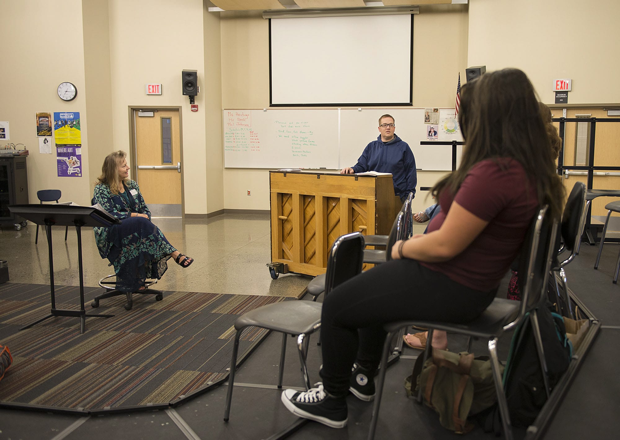 Long term substitute choir and drama teacher Deanna Hasting, left, joins students as they listen to their choir and drama teacher, Bob Meek, center, during choir practice Tuesday morning, Sept. 2, 2015.
