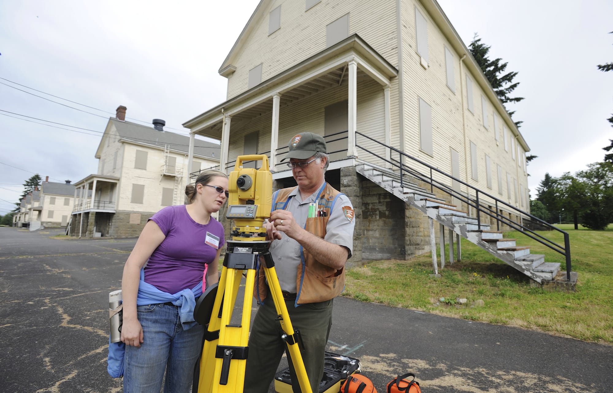 Graduate student Emily Taber and Doug Wilson, National Park Service archaeologist, use surveying equipment to set up a dig at the site of the 1854 Army flagstaff at Vancouver Barracks.
