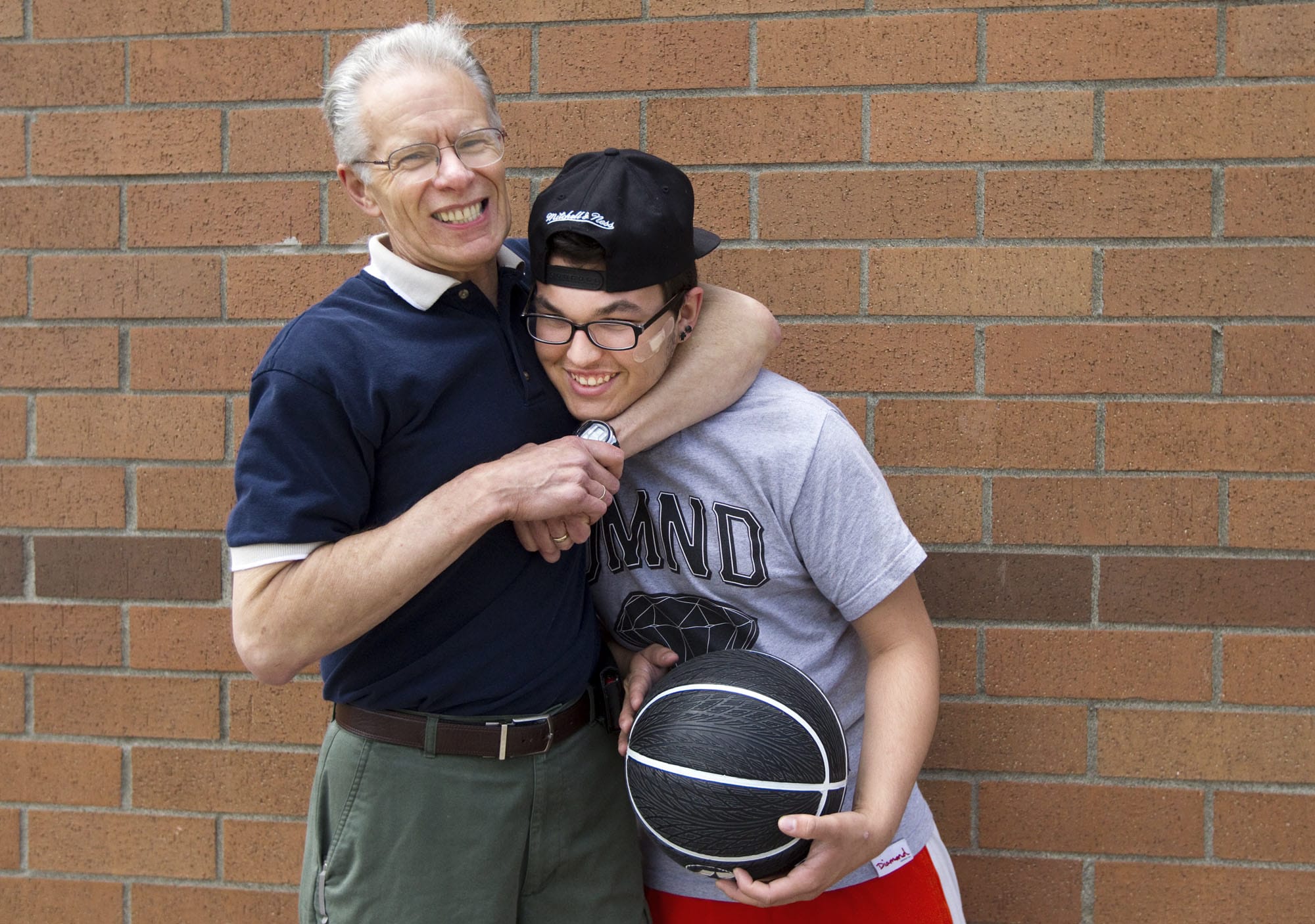 Jamie Stratton, left, shares a light-hearted squeeze with David Hinds, his &quot;little brother,&quot; during a break in shooting hoops at Fisher's Landing Elementary School on a recent Sunday afternoon.