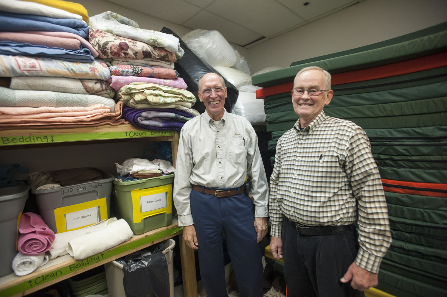 Pastor Jim Stender (L) and volunteer Denny Scott show a supply of bedding to be used in housing the needy this winter at Saint Andrew Lutheran Church in Vancouver Thursday September 16, 2015. The faith community aims to impact the affordable housing crisis.