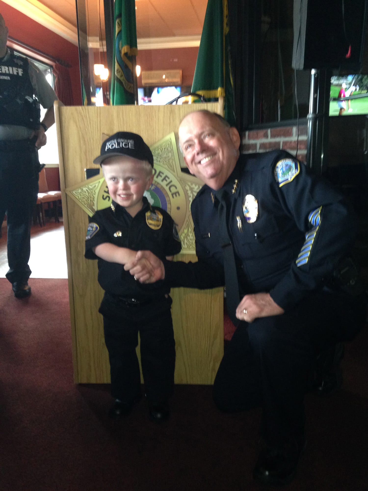 Battle Ground: Battle Ground Police Chief Bob Richardson shakes hands with honorary Police Chief Chase Getch, an 8-year-old boy with achondroplasia, a form of dwarfism.