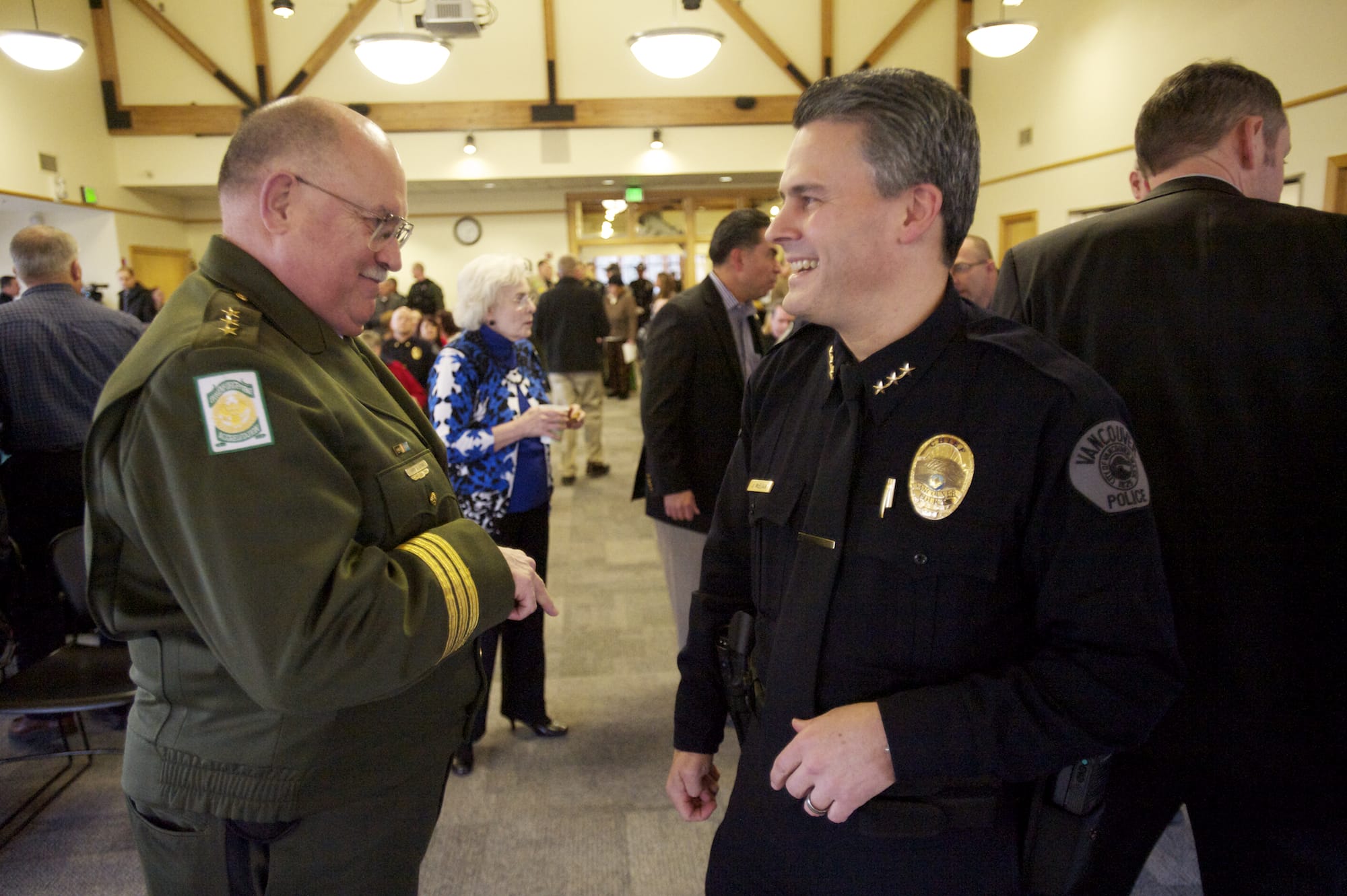 Vancouver Police Chief James McElvain talks with Clark County Sheriff Garry Lucas during a ceremony Thursday at the Water Resources Center in Vancouver.