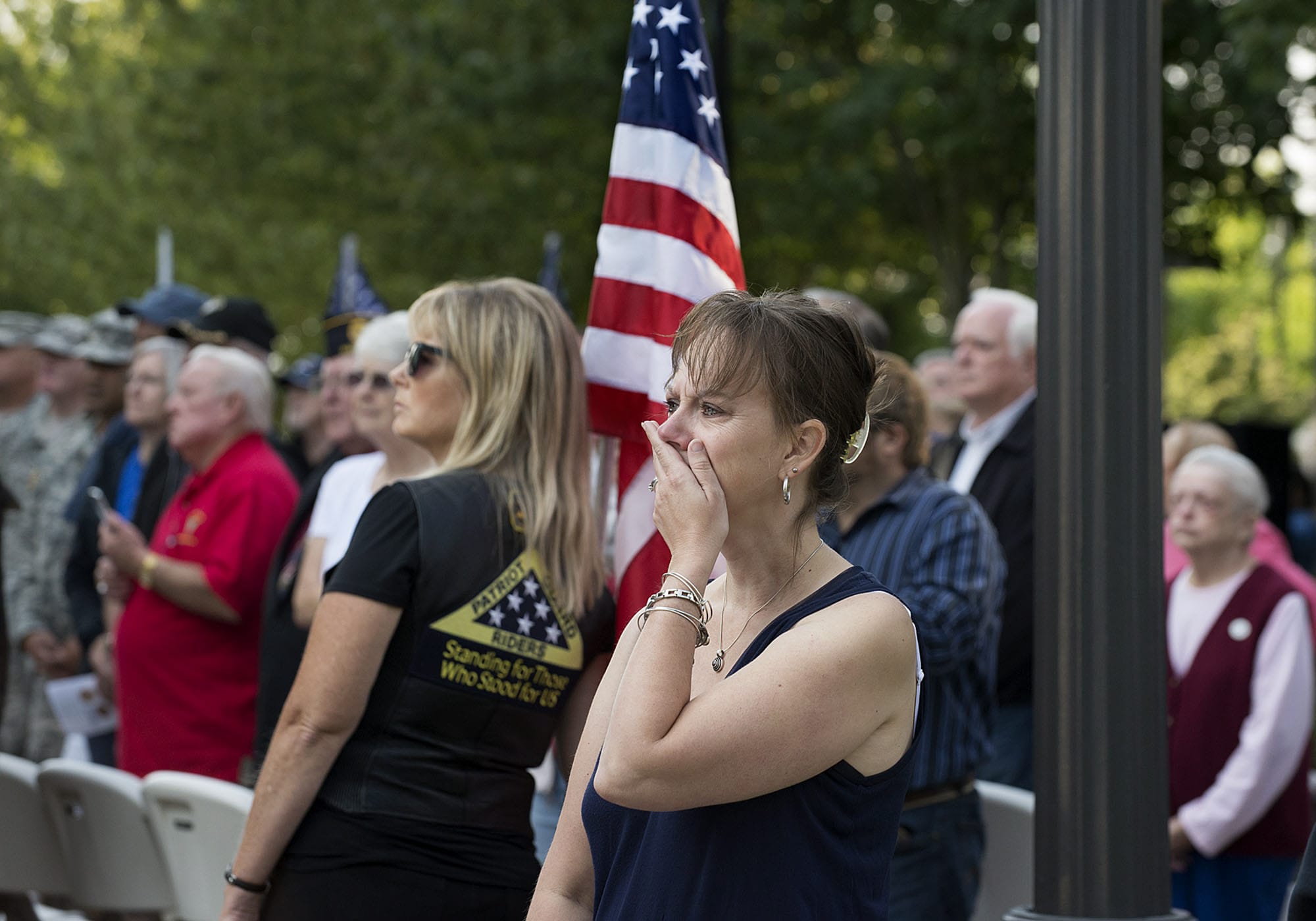 Christine Smith of Vancouver, center, and Mary Astrid of the Patriot Guard Riders, with flag, watch as doves are released in honor of the victims of Sept. 11, 2001 during a remembrance ceremony on Friday morning, Sept. 11, 2015 at Vancouver City Hall.