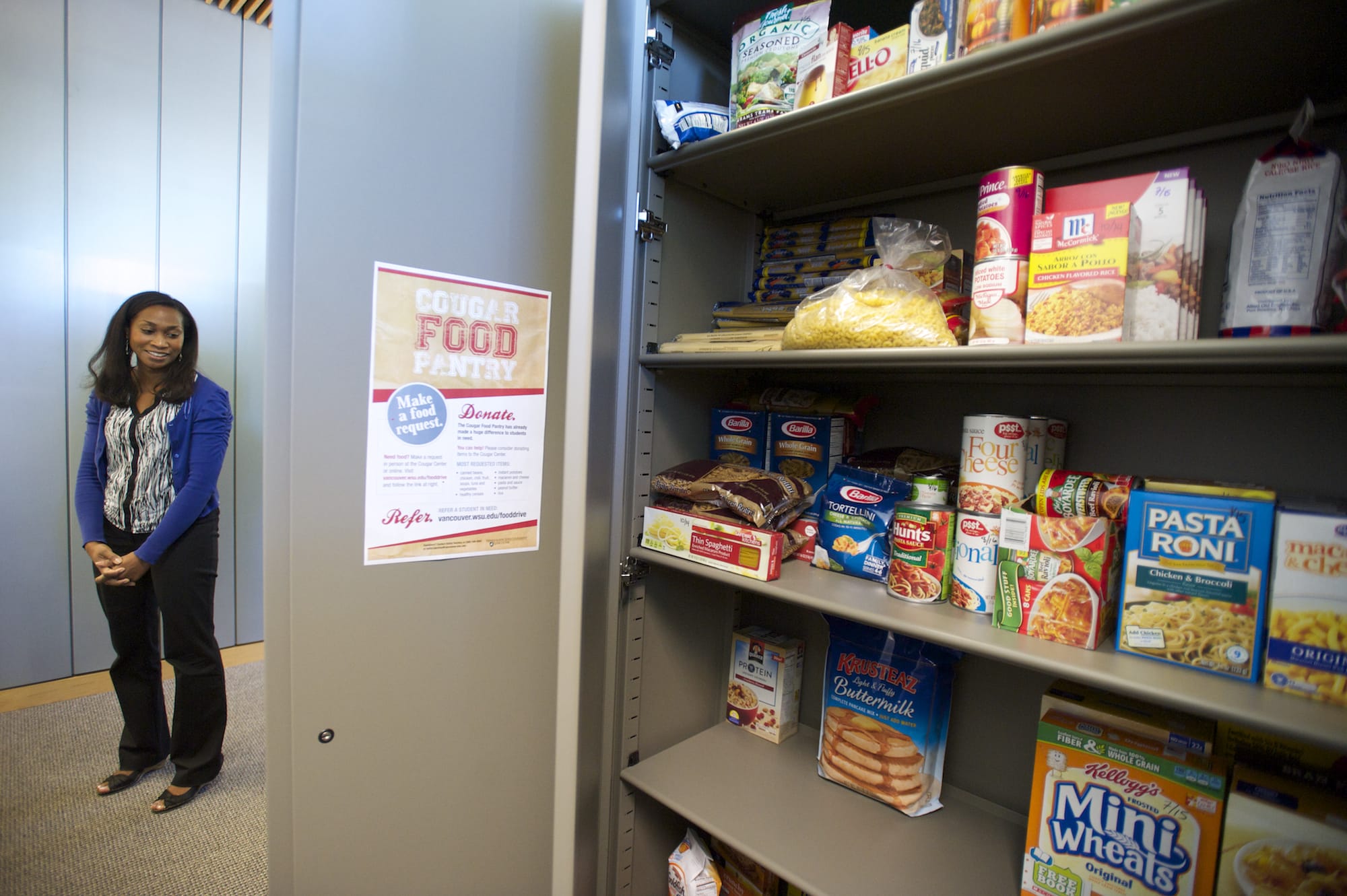 Kafiat Beckley, supervisor of the campus Cougar Center at Washington State University Vancouver, shows off the Cougar Food Pantry. She said the pantry got going when a financial aid system glitch in 2012 revealed just how needy some students were.