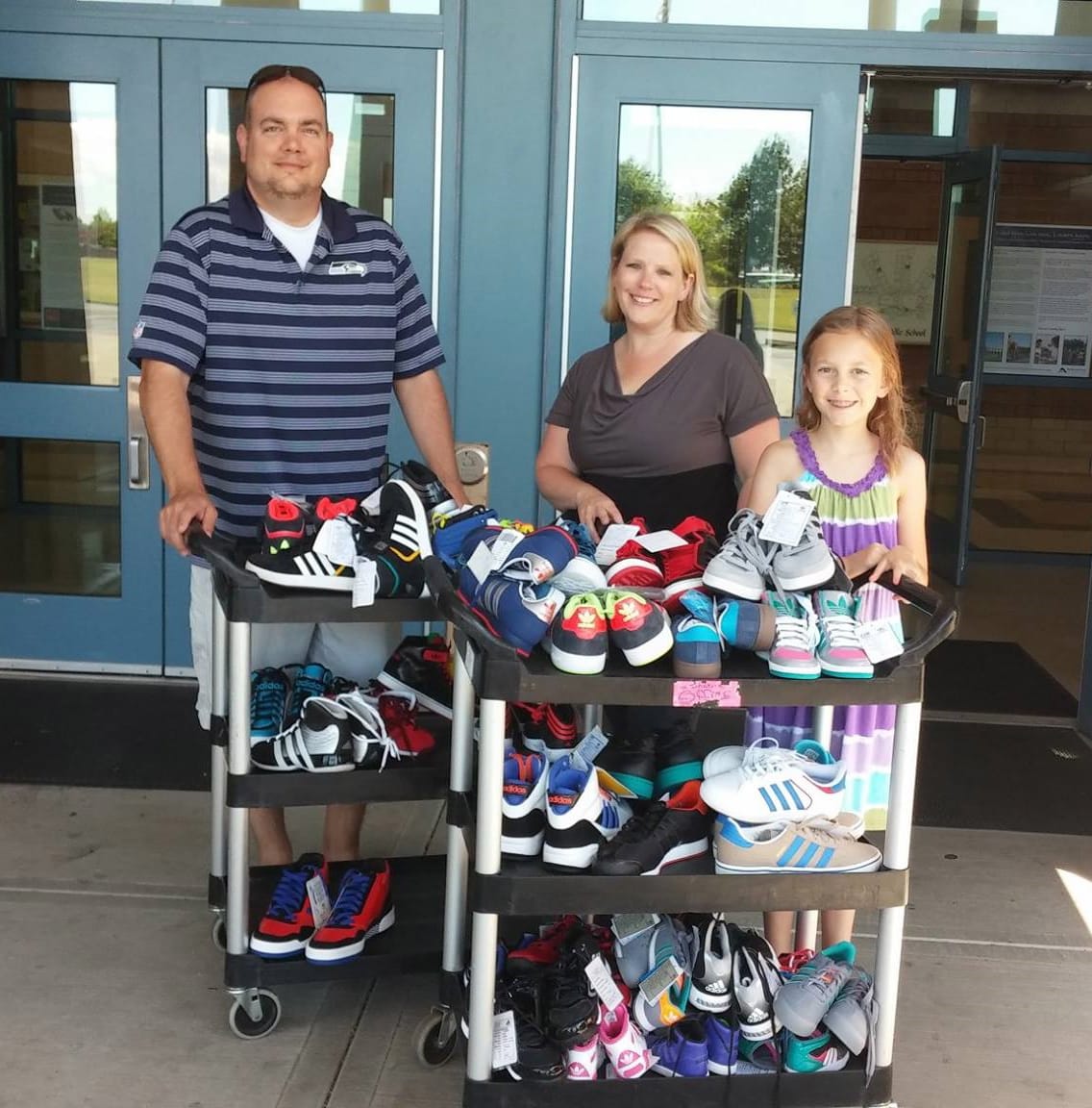 East Vancouver: Shahala Middle School Principal Gregg Brown, from left, staff member Katie Cowles and student Grace Brown with some of the 200-plus pairs of shoes the school&#039;s shoe drive brought in for Share.