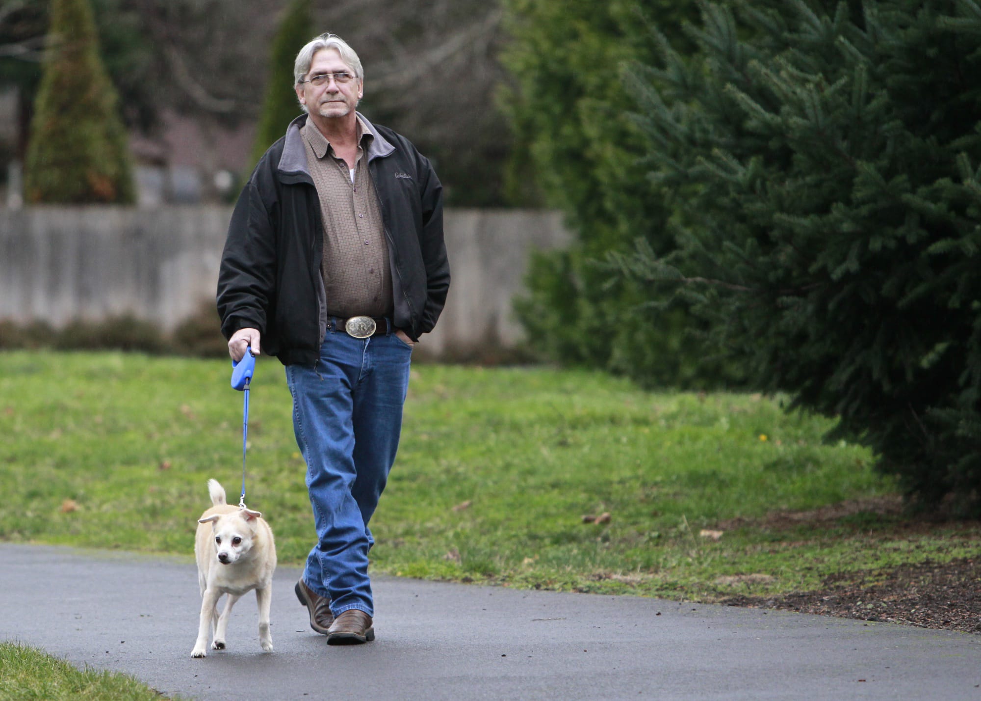 Ray Tabor walks his dog Toby near PeaceHealth Southwest Medical Center on Wednesday. Tabor spends more time walking Toby after an acute heart attack and a subsequent critical arrhythmia nearly killed him.