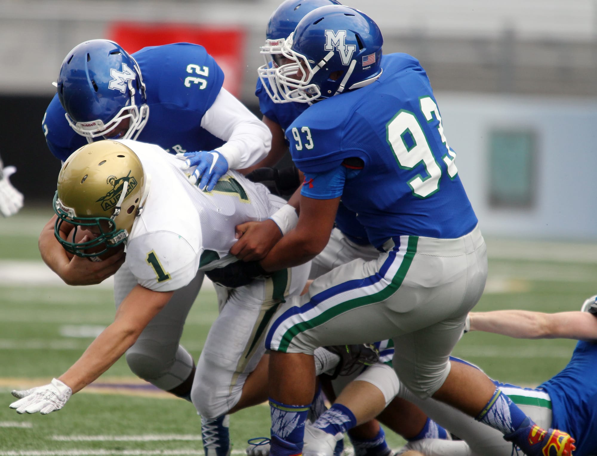 Mountain View's Kimball Elliott (32), Isaiah Carbajal (59) and  Chandler Alvarado (93) bring down Auburn's quarterback Justin Tuia in the first quarter of the 2015 Emerald City Kickoff Classic at Husky Stadium  in Seattle.