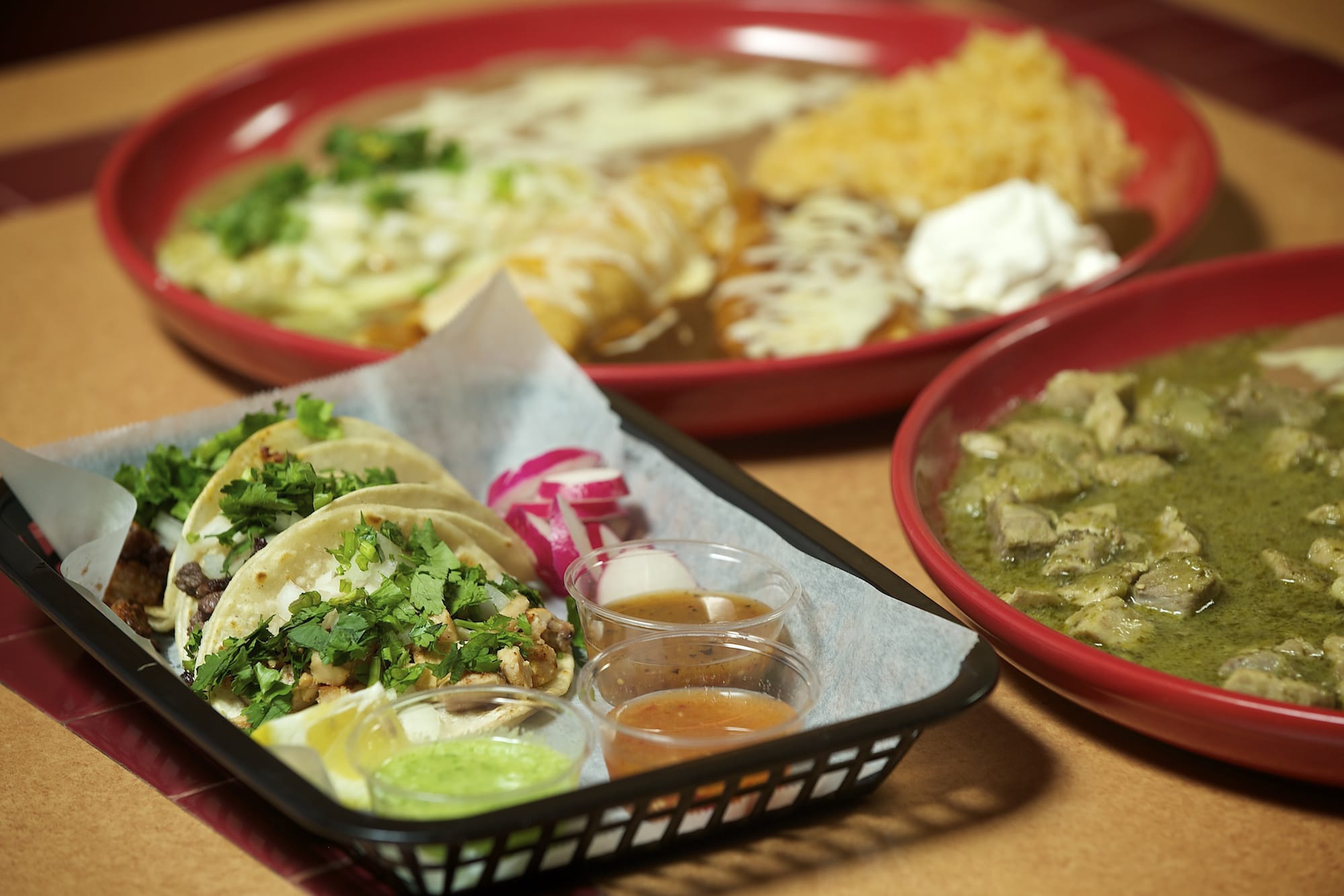 An enchilada sampler, background, chili verde, right, and street tacos (one steak and one chicken) are some of the menu items offered at Lindo Mexico Restaurant &amp; Cantina in Vancouver.