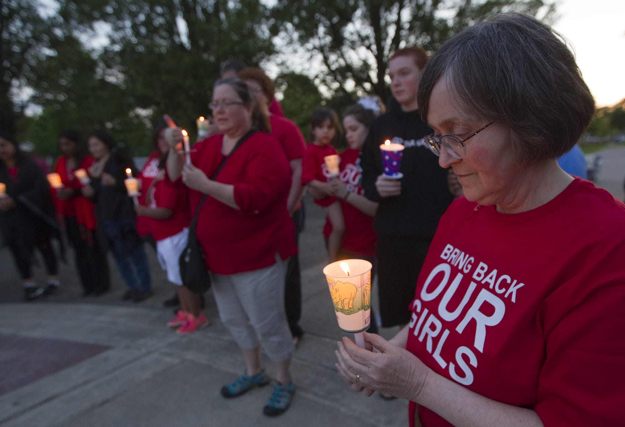 Gabby Sprenger, right, holds a candle as part of a Friday vigil at Clark College for 276 Nigerian girls who were kidnapped from school last month.
