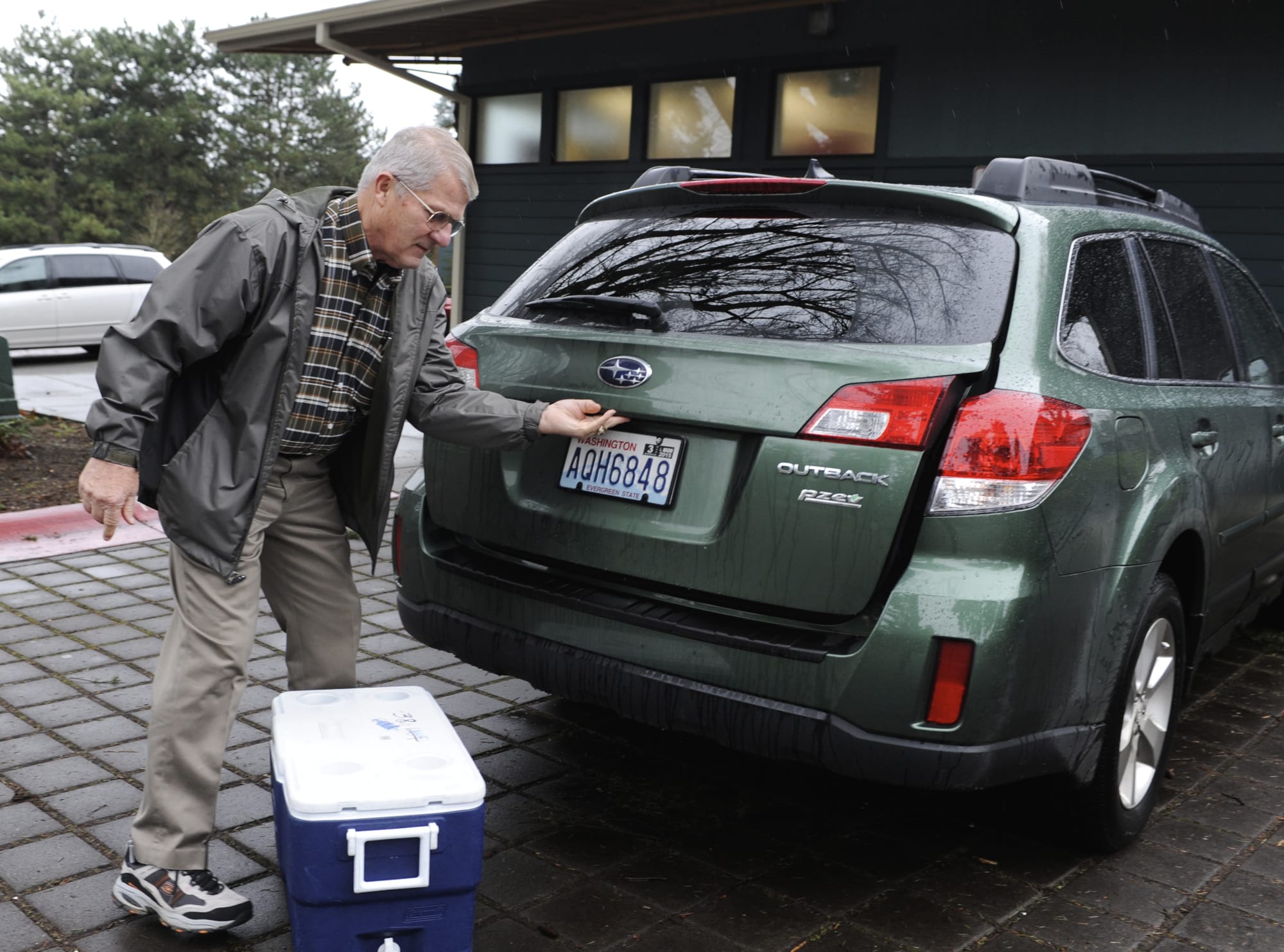 Vancouver City Councilor Larry Smith, who drives once a week for Meals on Wheels, loads his car at the Luepke Senior Center in Vancouver, Wa., Thursday., Dec 18, 2014.