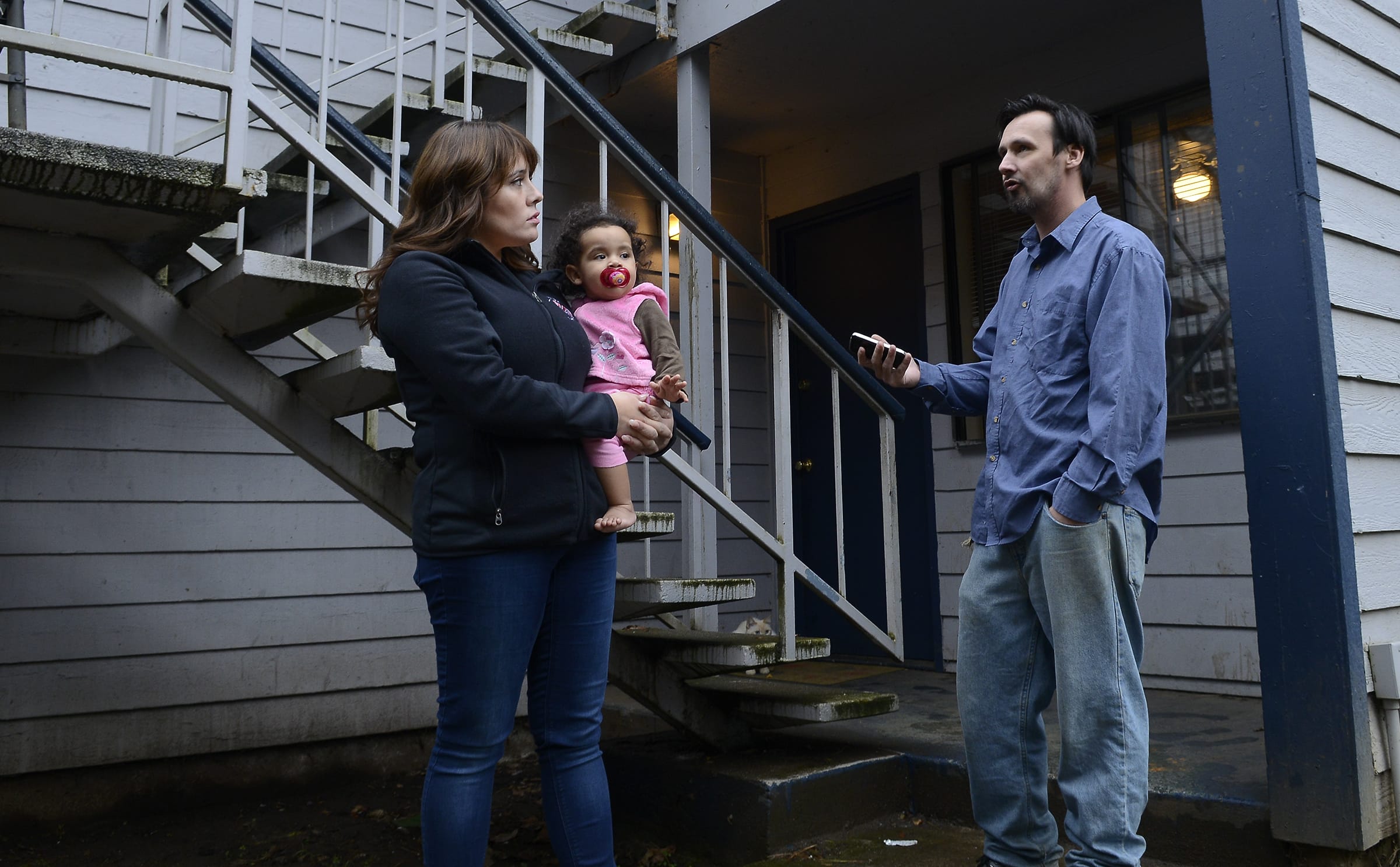 Natalia Mosley, holding onto daughter Isabel, chats with neighbor Kevin Giard about the upheaval at Courtyard Village Apartments, where new owners have begun notifying residents that they'll need to leave because of pending renovations and rises in rent.