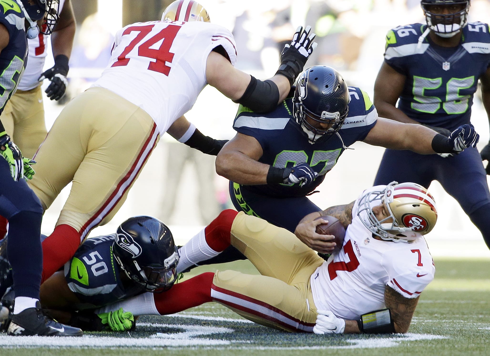 San Francisco 49ers quarterback Colin Kaepernick is sacked by Seattle Seahawks defensive tackle Jordan Hill (97) and outside linebacker K.J. Wright (50) in the first half against the Seattle Seahawks, Sunday, Dec.