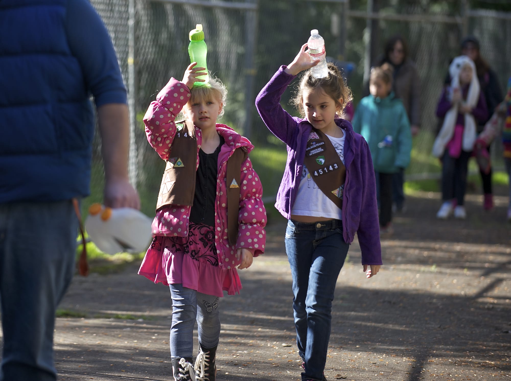 Zayah Shore, left, and Taylor Chriss, 7-year-old Brownies with Girl Scout Troop 45143, carry water during an activity hosted by the Water Resources Education Center to honor World Water Day.