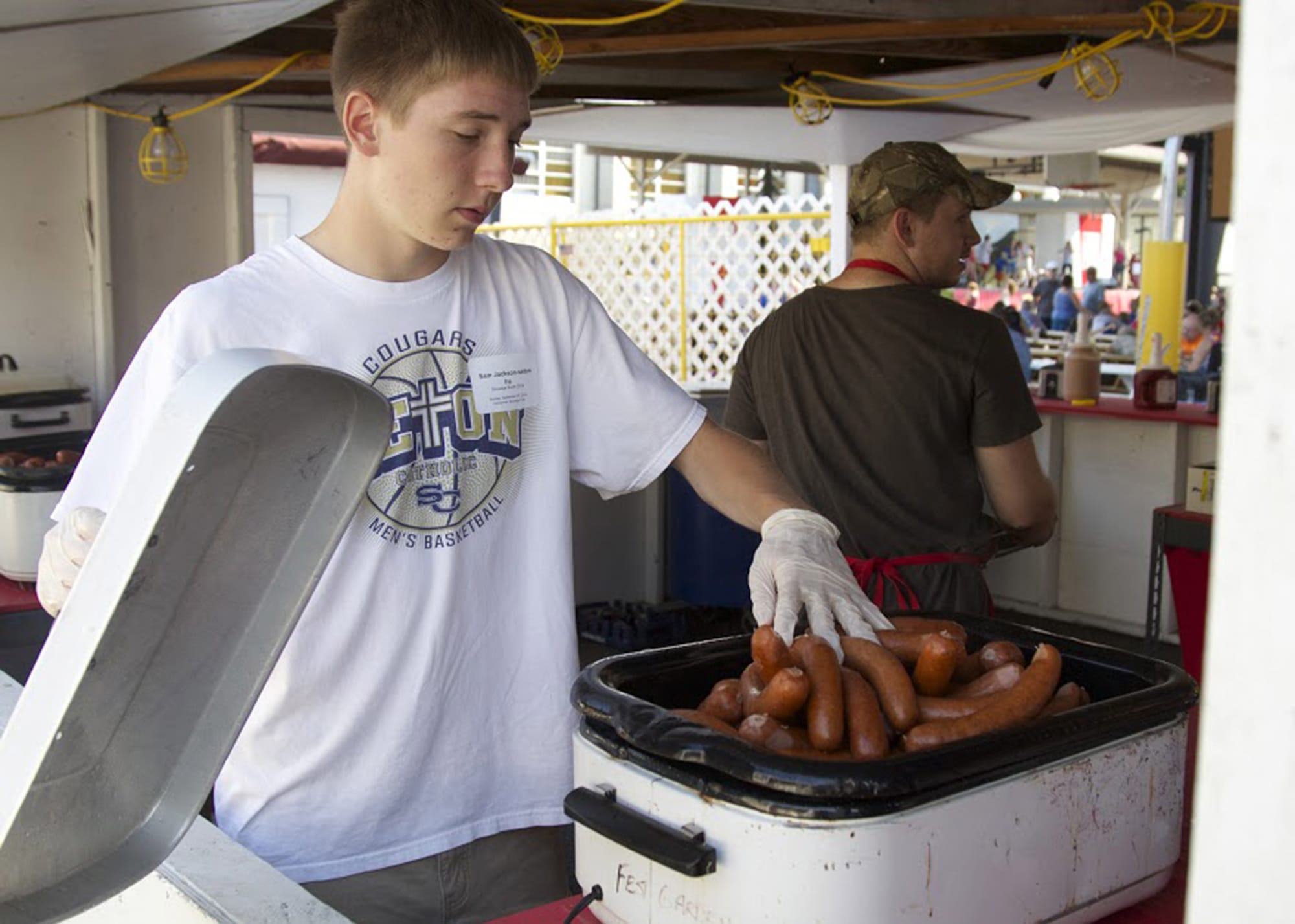 Garrett Wellman, 15, of Battle Ground works inside the sausage booth at the Vancouver Sausage Fest on Sunday, Sept. 7, 2014. The group had nearly sold out of original sausages by 3 p.m.