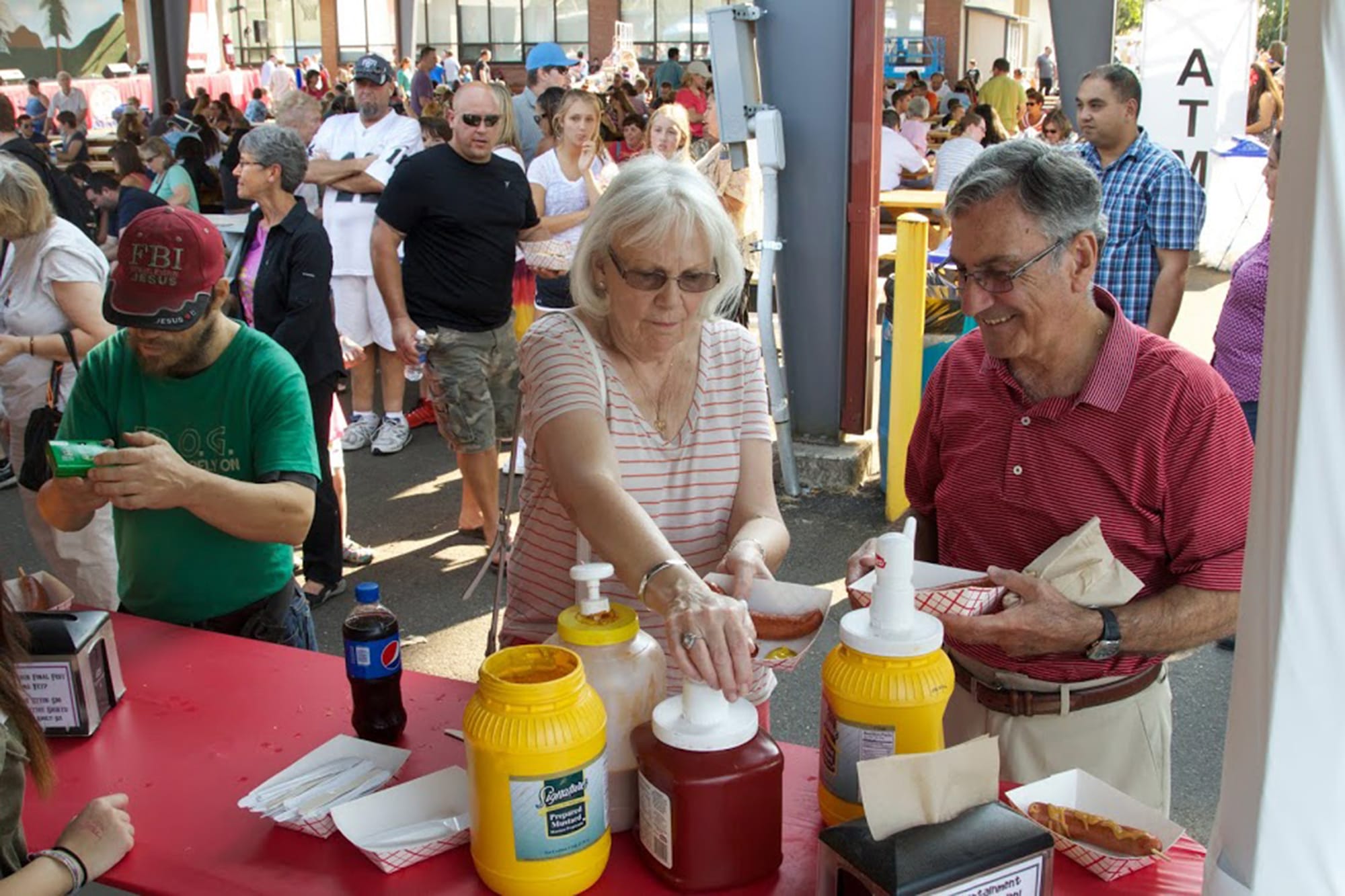Liz and Raif Zacca of Vancouver get condiments for their sausages at the Vancouver Sausage Fest on Sunday. The two attend St.