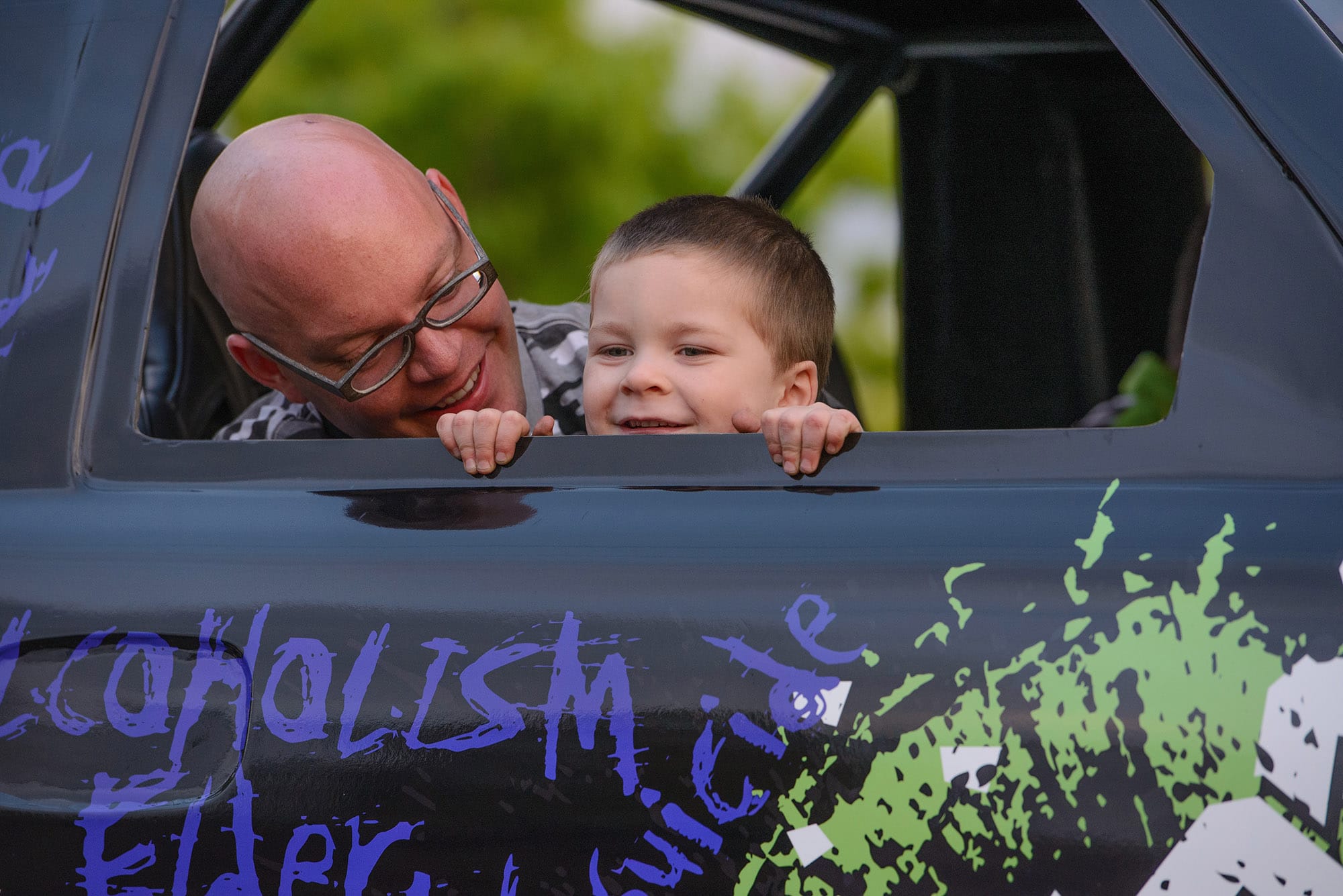 Gideon Janku, 4, sits in a monster truck with his dad, Scott Janku, during a special car show organized just for him May 16 in the East Vancouver Home Depot parking lot.