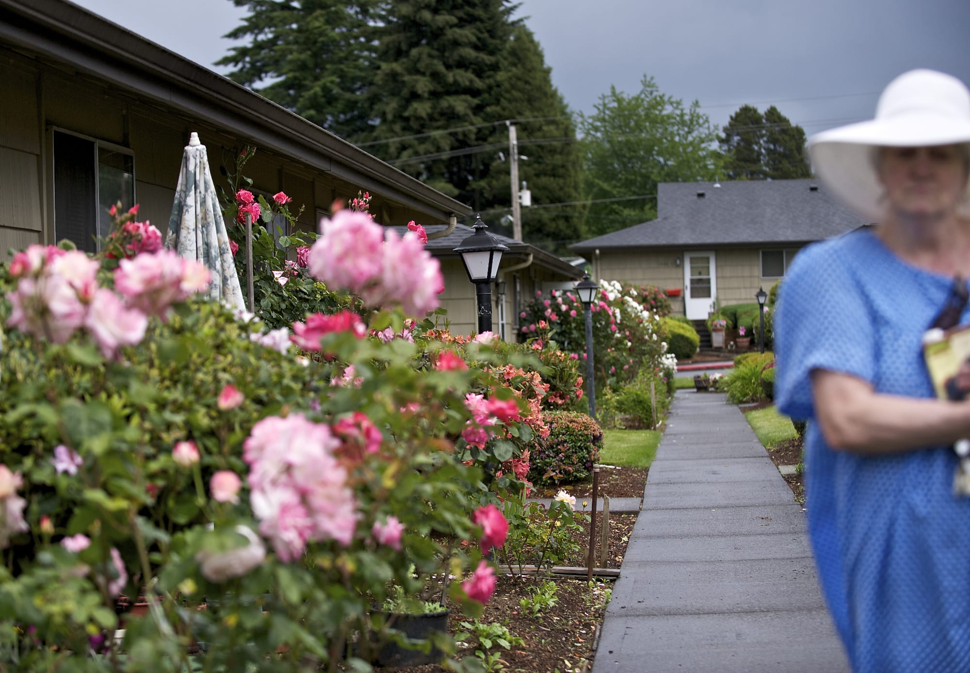 Vancouver resident Diana Robinson walks past a row of flower gardens at her apartment complex last week.