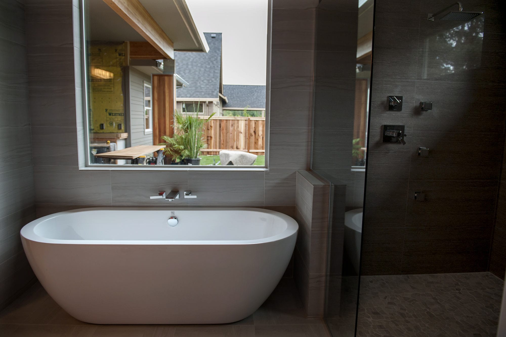 The master bathroom in The Hyfield hosts a bathtub, shower and views of the backyard.