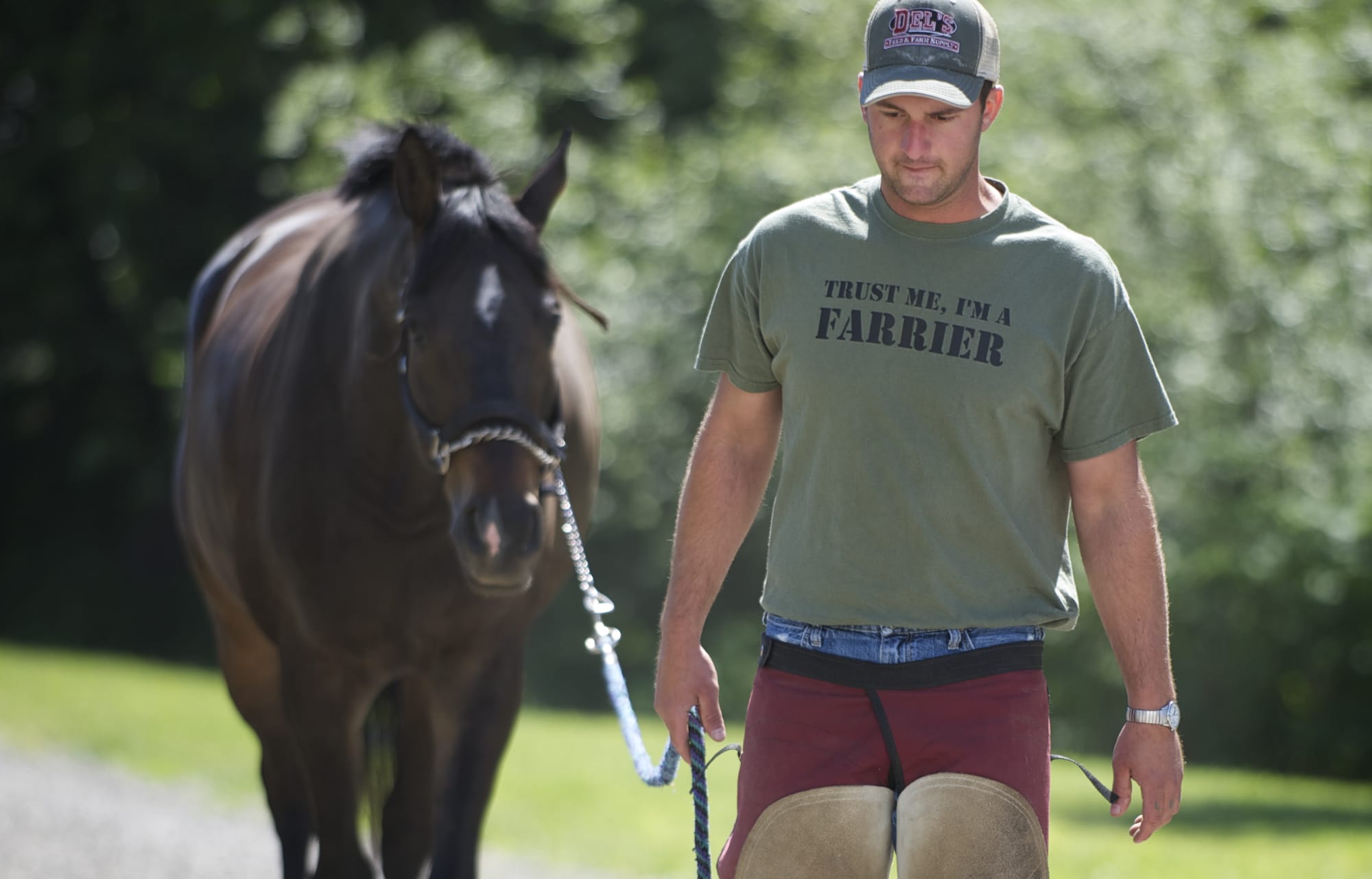 Farrier Chris Wilson walks a horse to a barn to shoe him June 5 at a stable in Ridgefield.